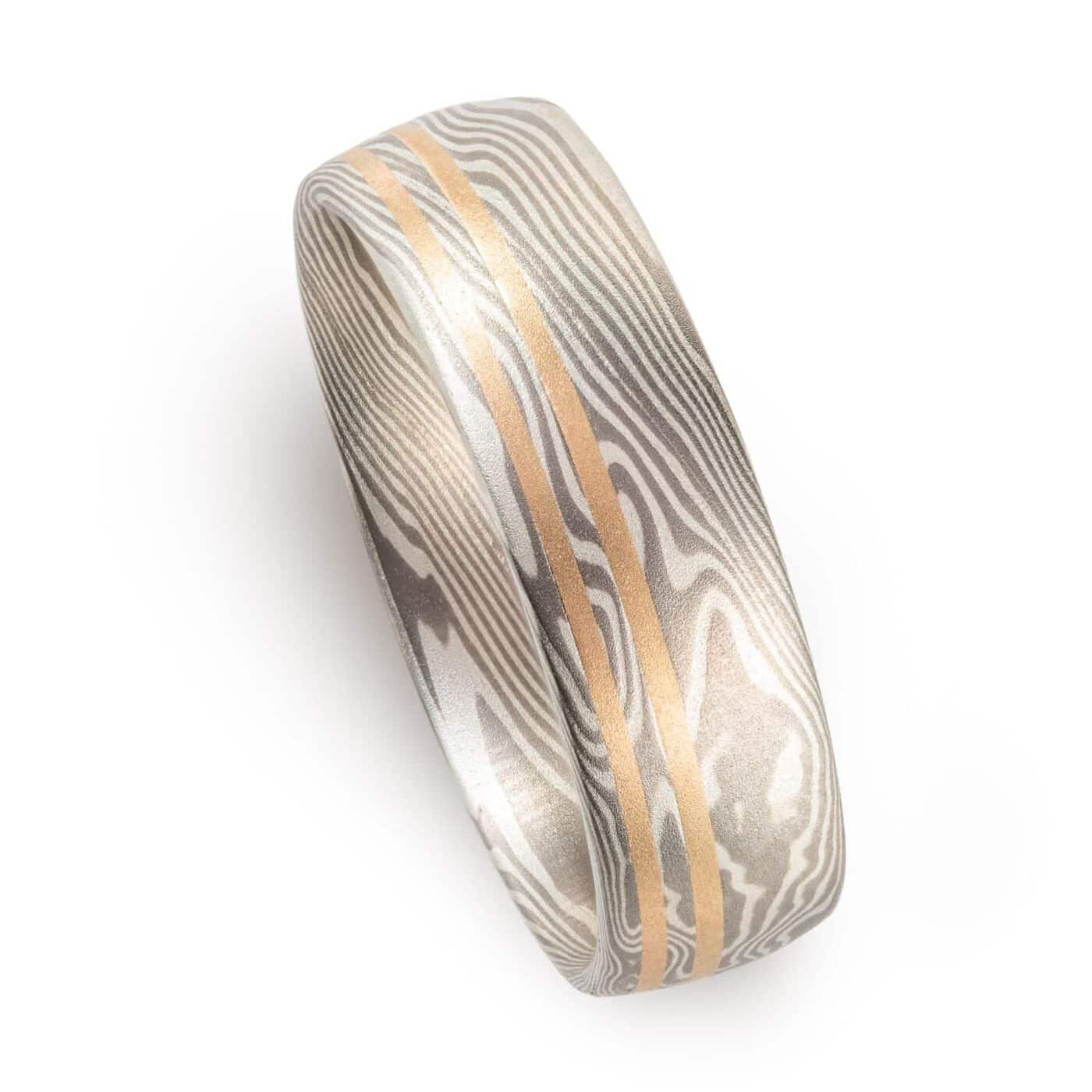 mokume gane silvery ring with two yellow gold lines running perfectly parallel around the band