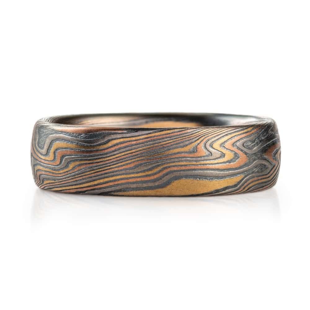 twisted pattern mokume ring, overall darker looking, made with yellow and red golds and palladium and oxidized silver