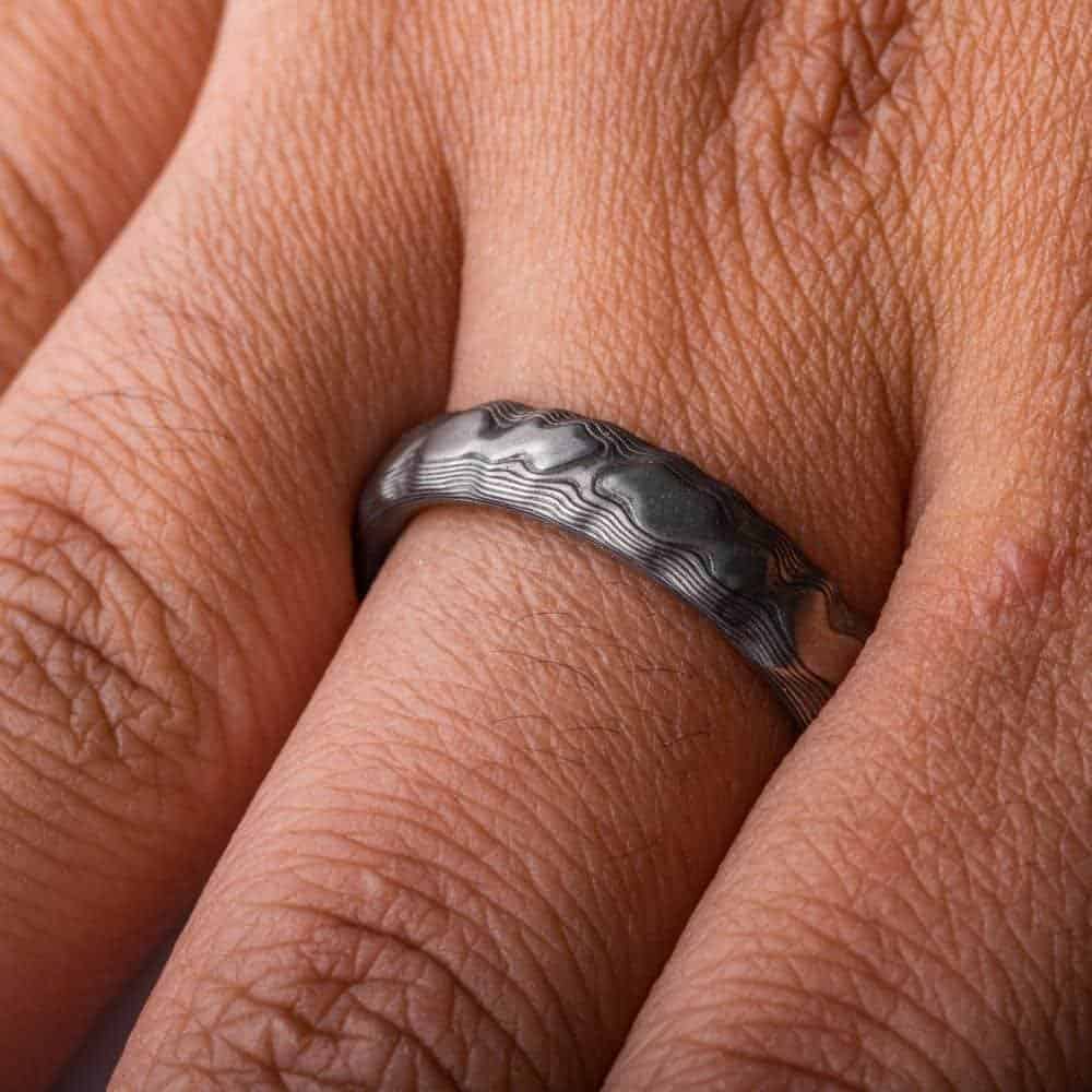 textured mokume ring made to look like rock formation, overall dark gray palette