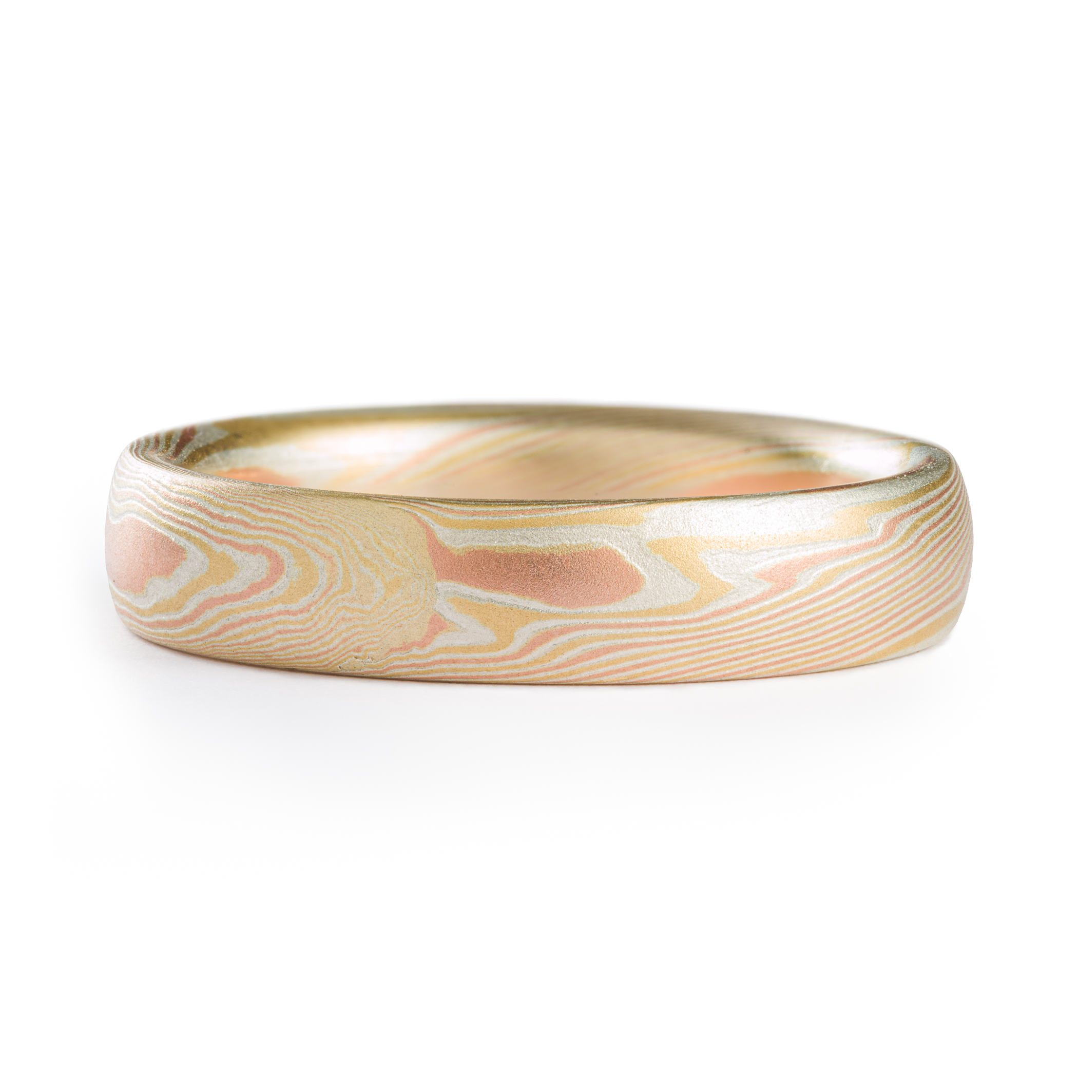 Yellow and red gold mokume gane patterned ring, made in an organic twisting pattern that resembles wood grain.