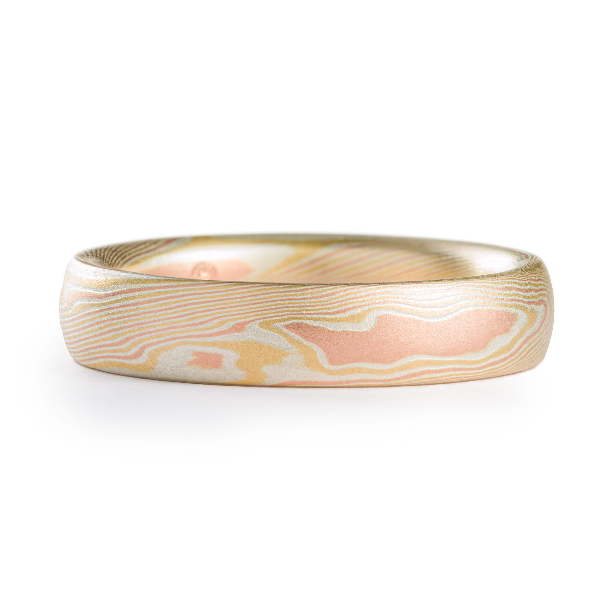 Yellow and red gold mokume gane patterned ring, made in an organic twisting pattern that resembles wood grain.