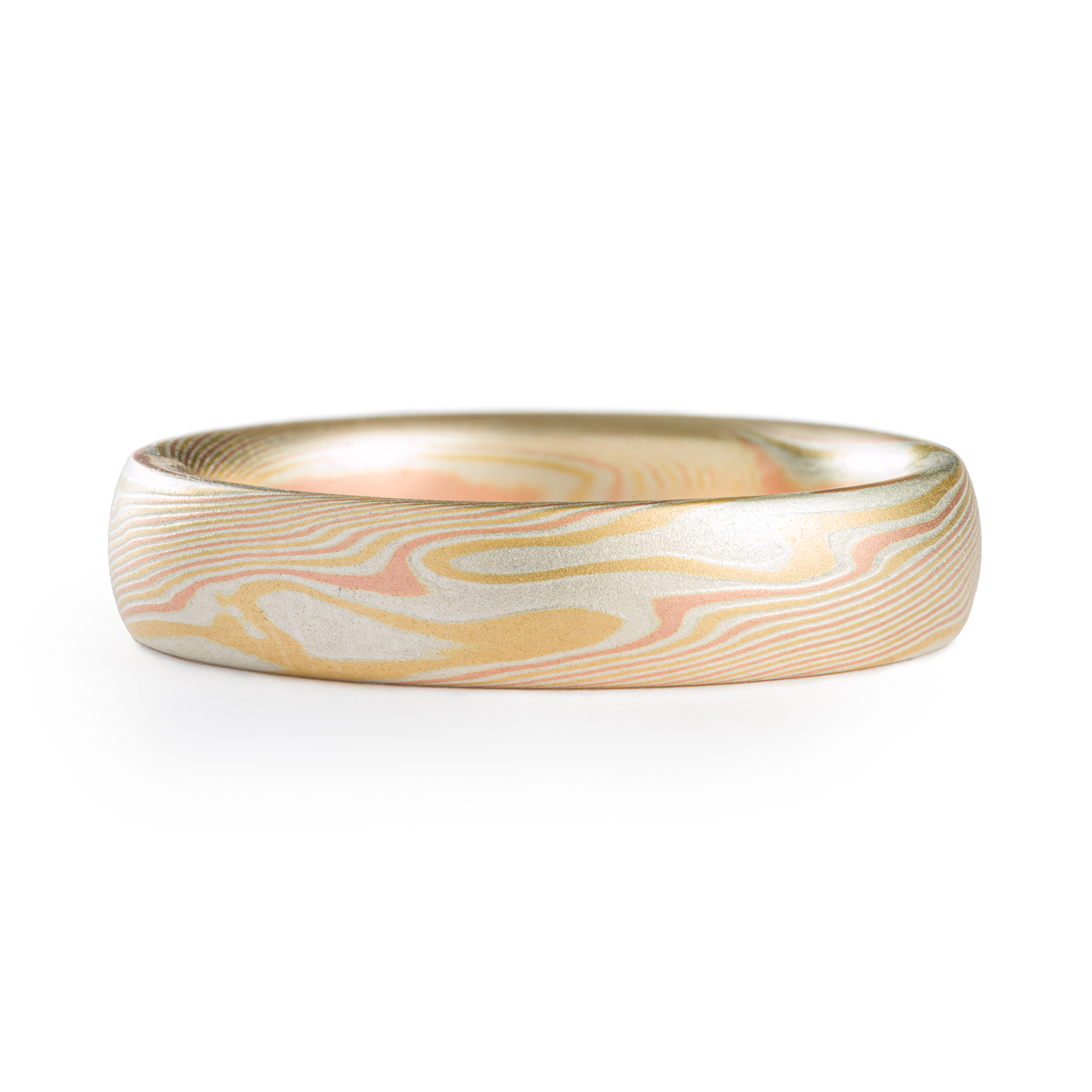 Yellow and red gold mokume gane patterned ring, made in an organic twisting pattern that resembles wood grain.