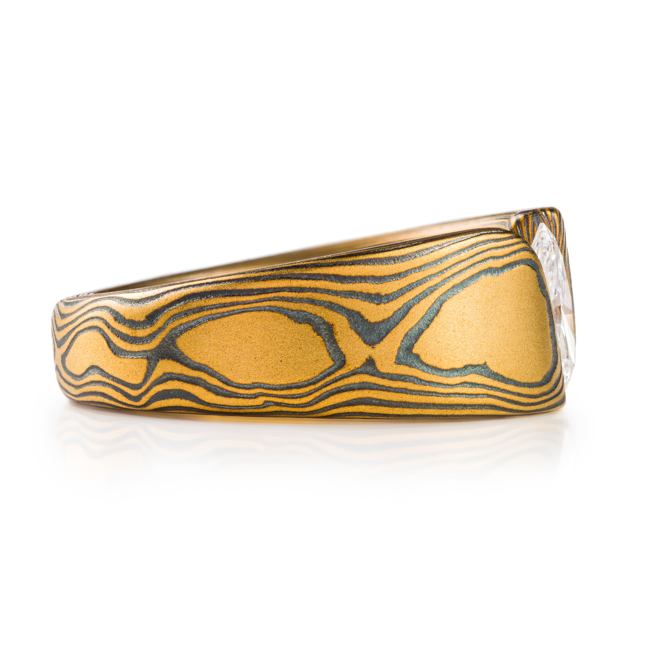 large and bold mokume gane tension set ring, featuring a beautiful marquise cut diamond set at an angle