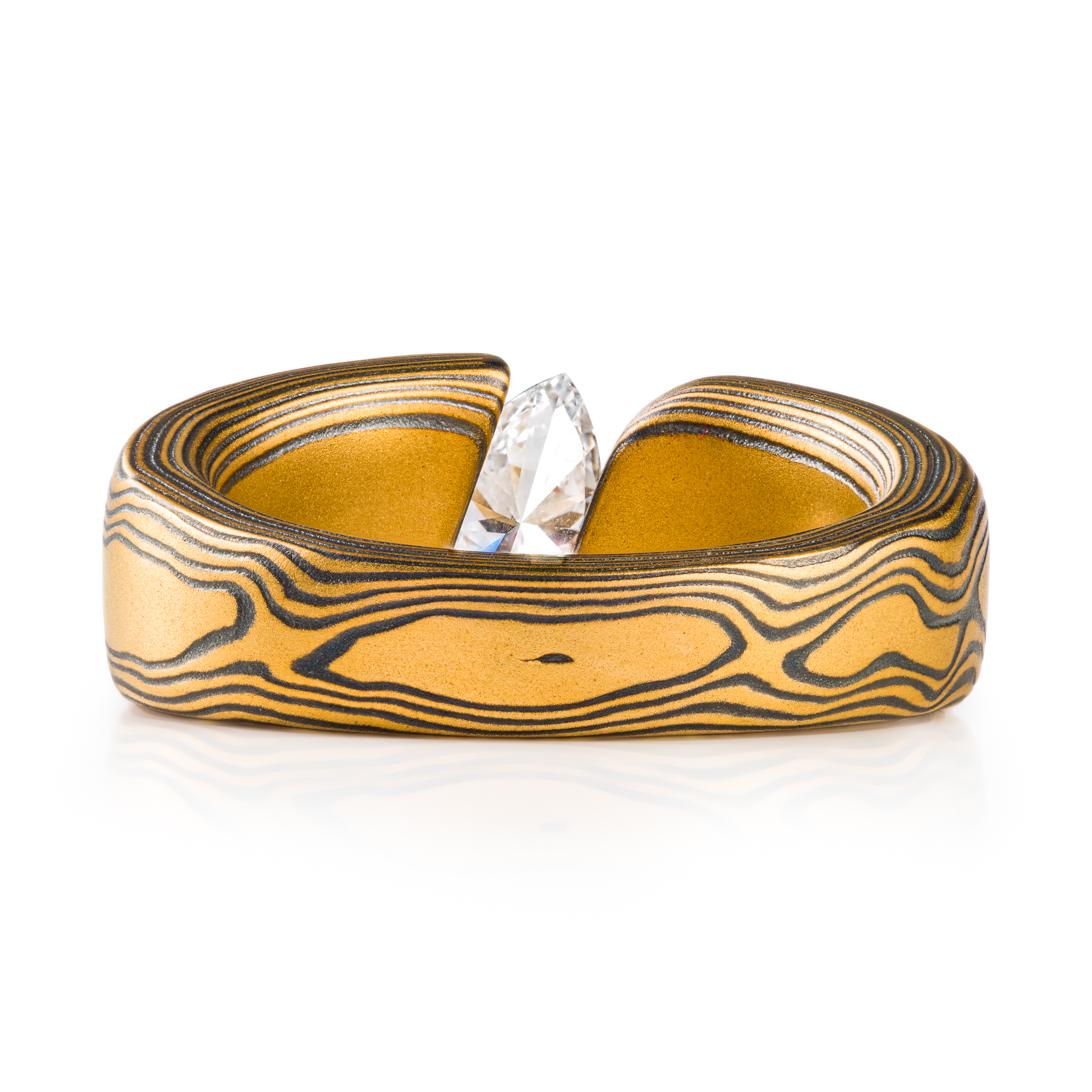 large and bold mokume gane tension set ring, featuring a beautiful marquise cut diamond set at an angle