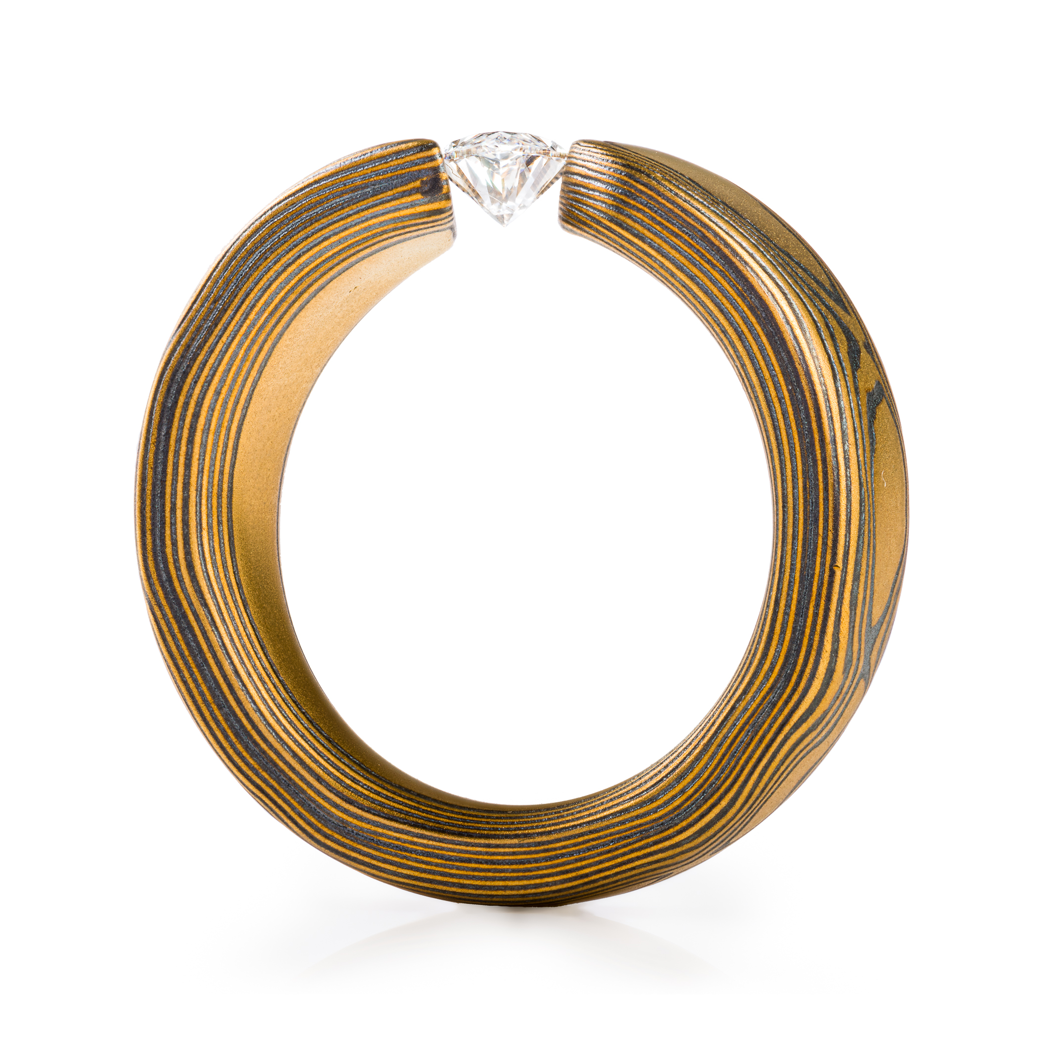large and bold mokume gane tension set ring, featuring a beautiful marquise cut diamond set at an angle