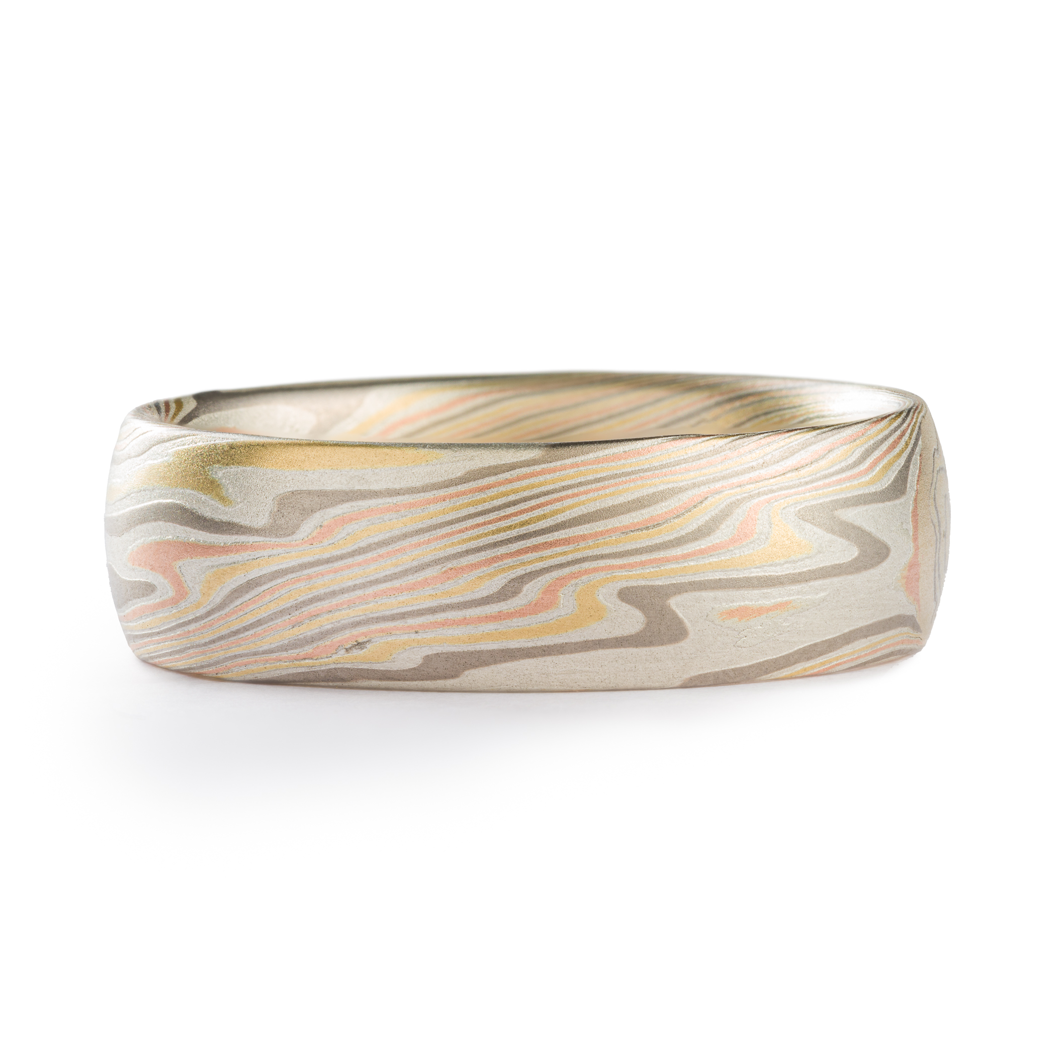 mens ring in mokume gane band with domed profile, made in a twisted pattern with diagonal lines running across, with red and yellow gold, palladium, and etched silver