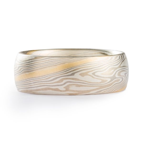 light colored mokume gane twist pattern band with a single stripe of yellow gold running around, smooth finish and domed profile