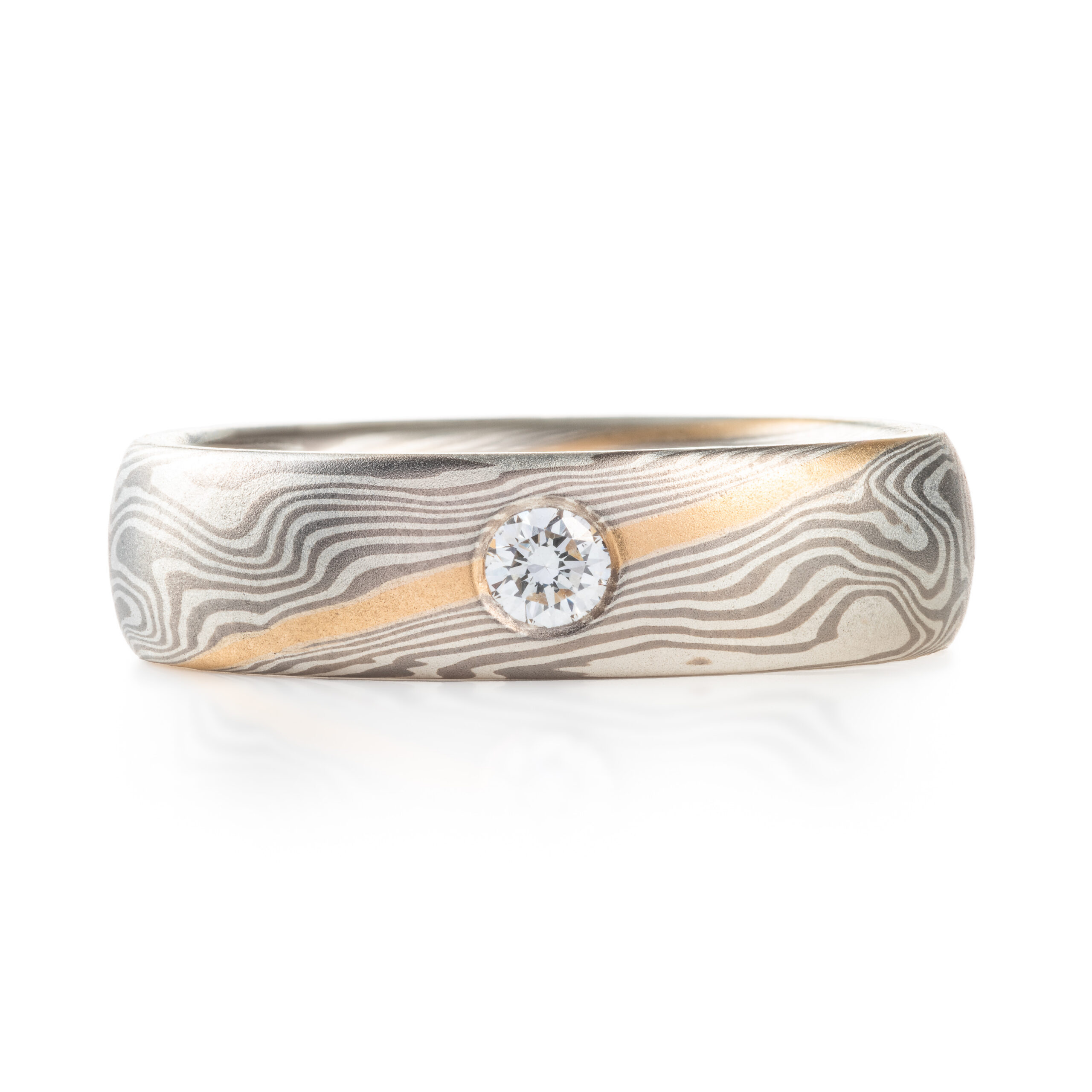 mokume gane band with a flush set diamond and an added yellow gold stratum layer