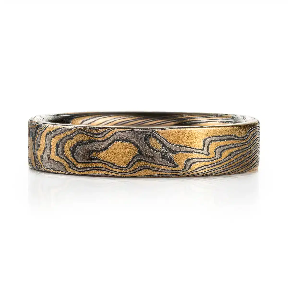 rustic gold mokume gane band with a flat profile ring, high contrast with oxidized silver