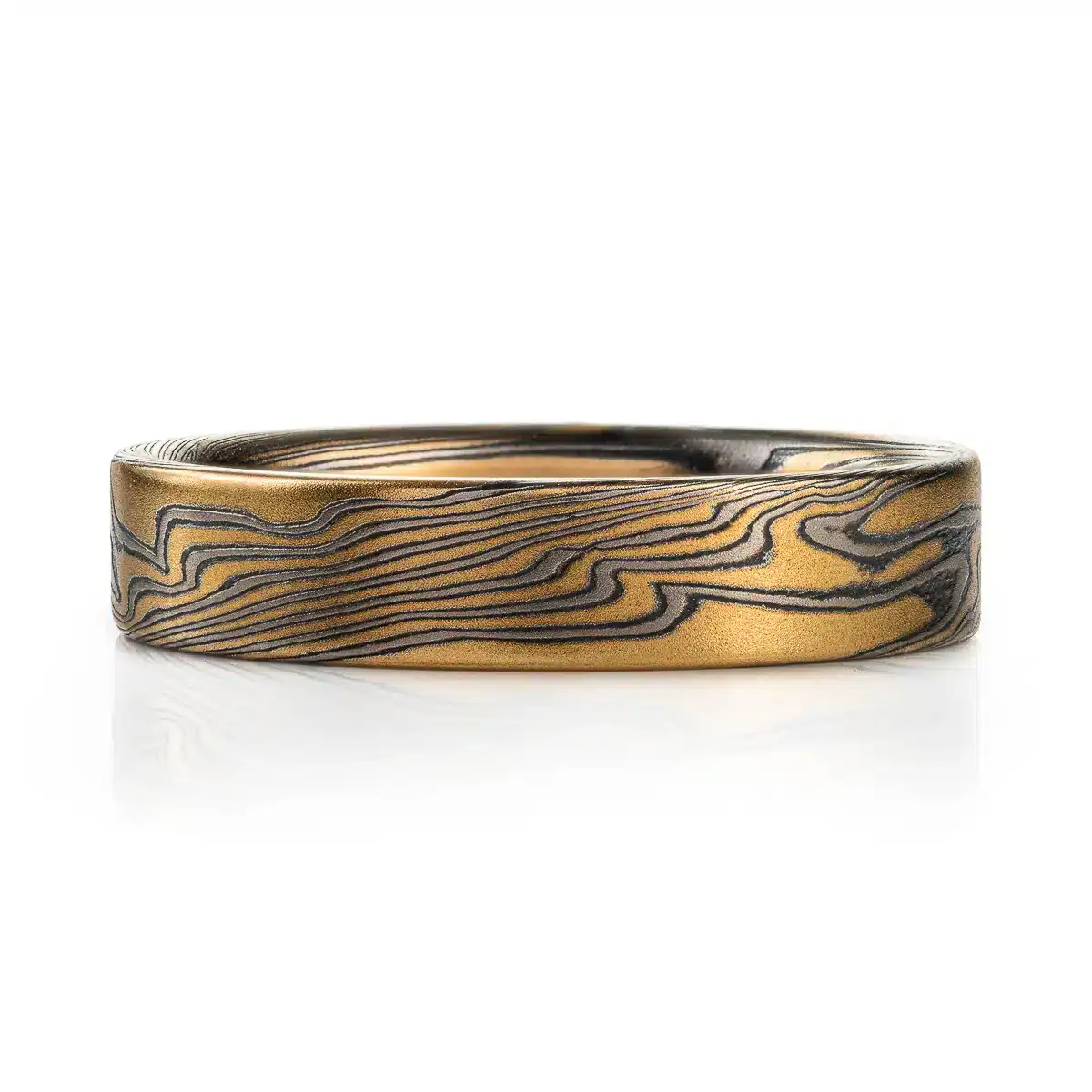 rustic gold mokume gane band with a flat profile ring, high contrast with oxidized silver