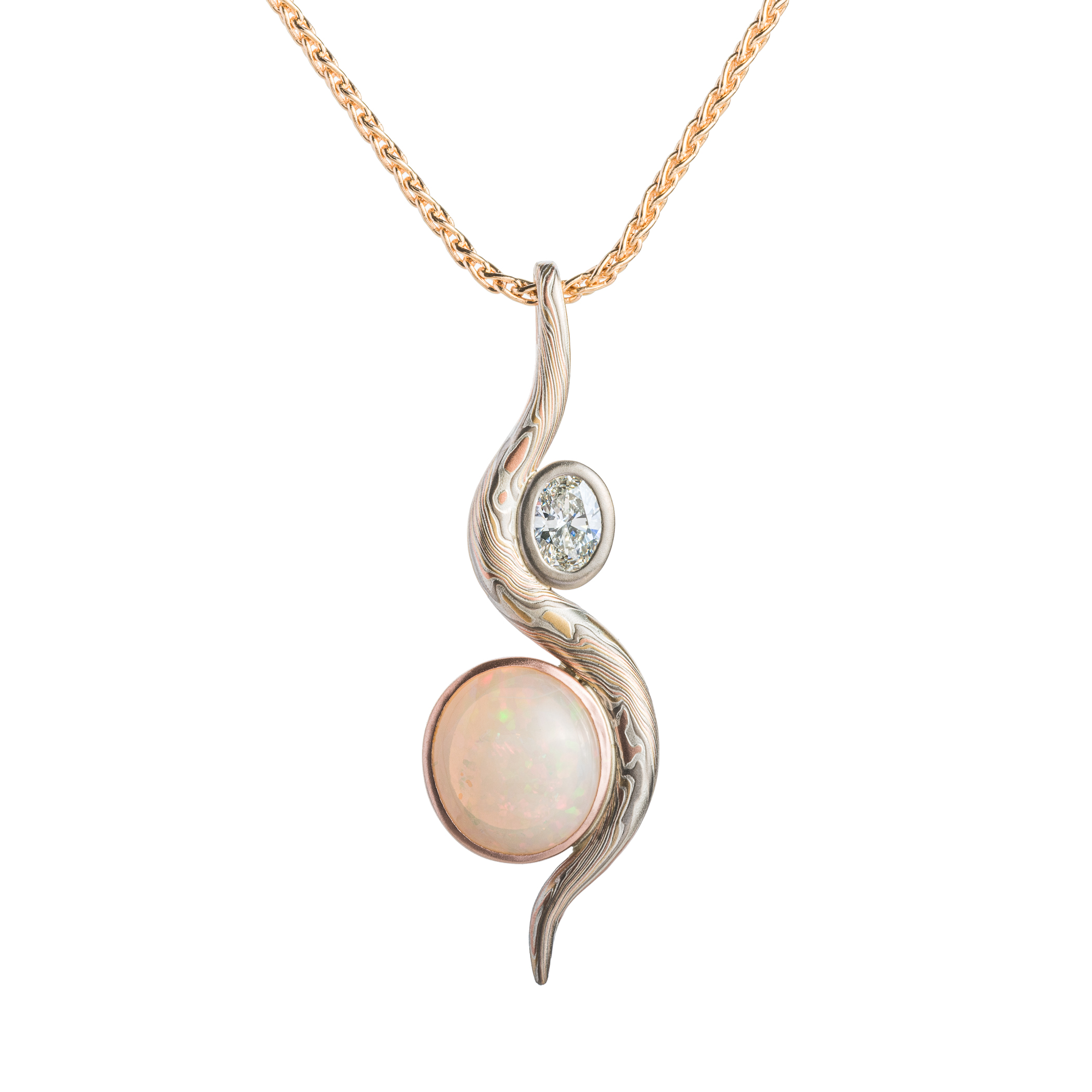 Elegant pendant made with a slender snake of patterned mokume gane gently curling around two oval shaped stones.