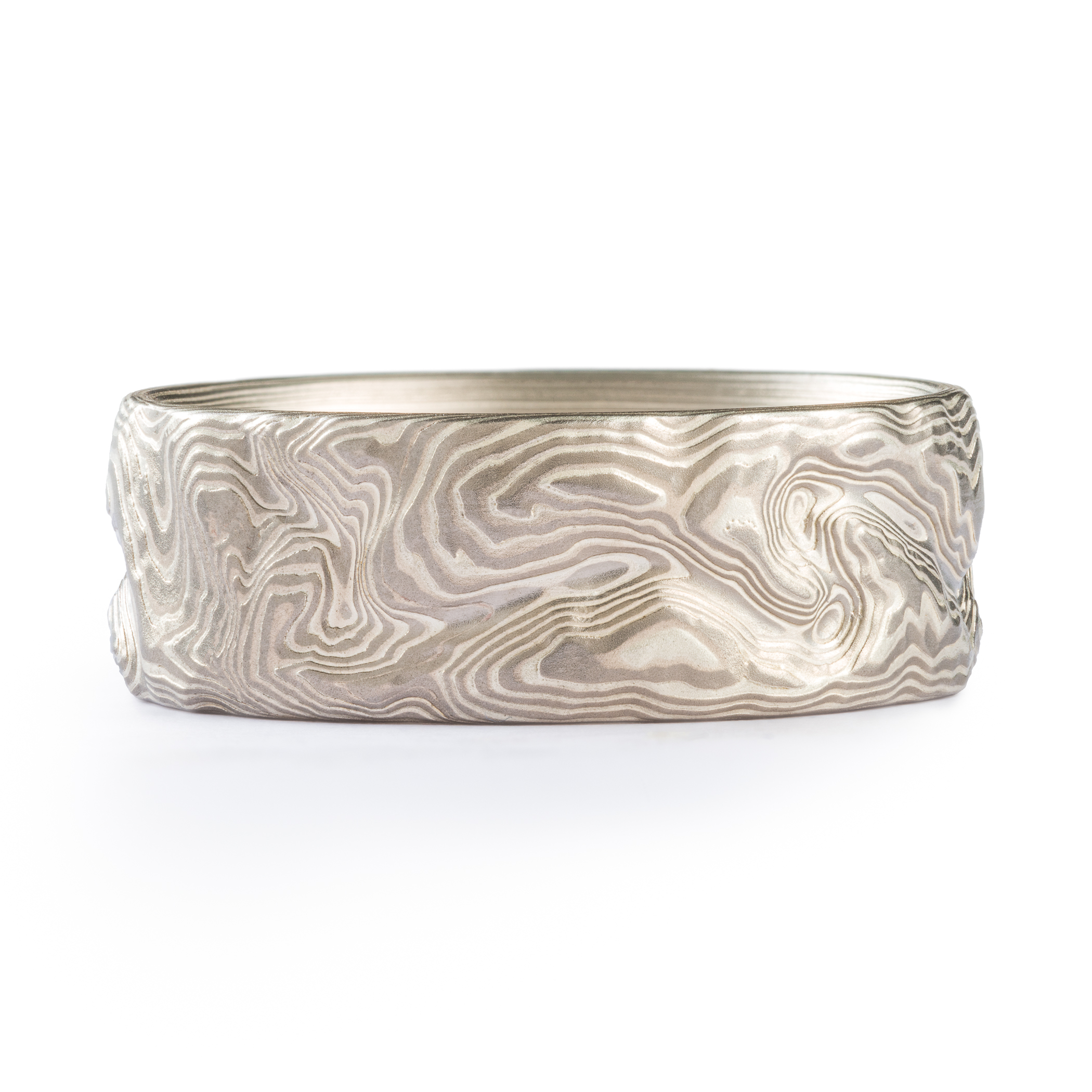 Custom carved mokume gane ring where the pattern resembles the topographic map of a specific place. Made with palladium and etched silver.