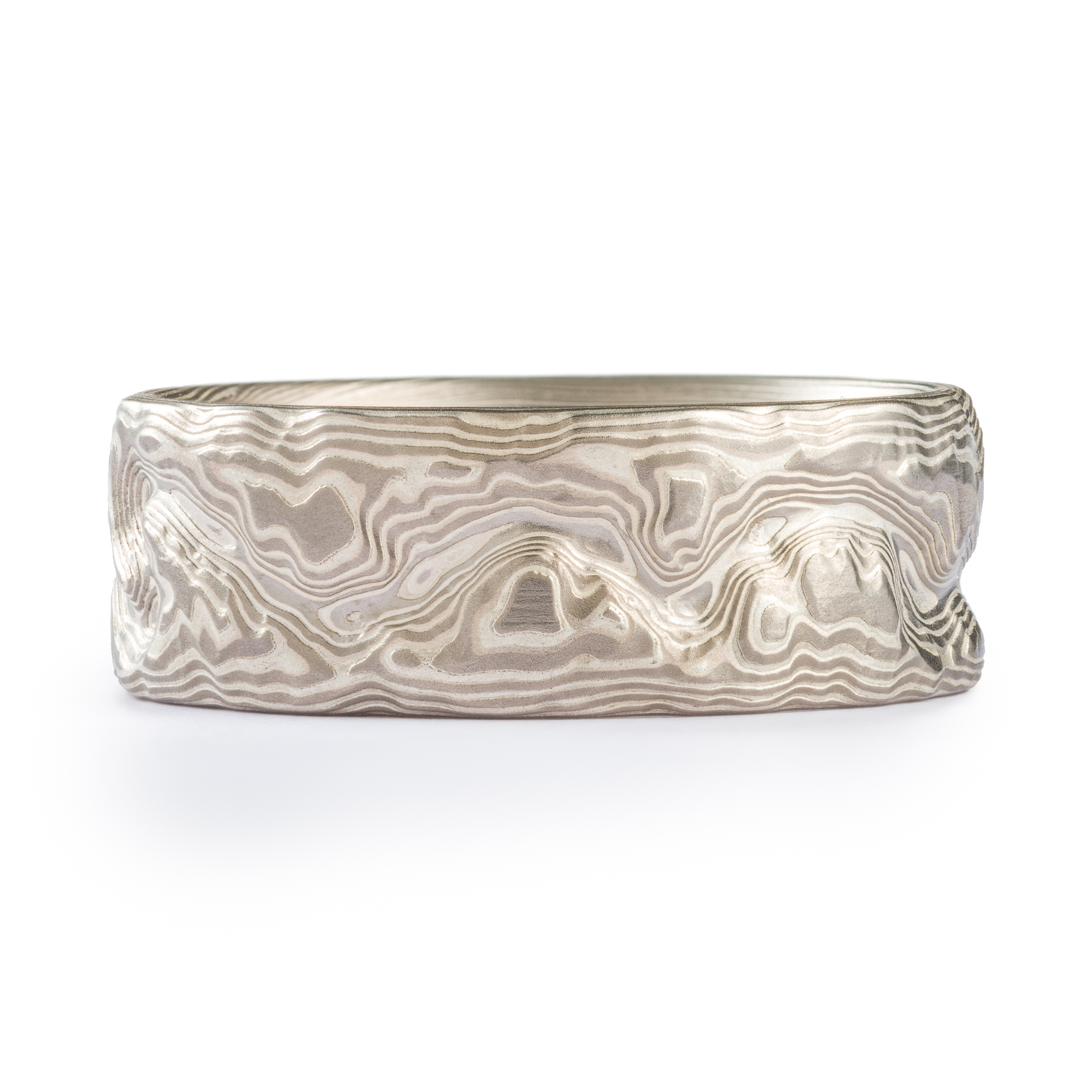 Custom carved mokume gane ring where the pattern resembles the topographic map of a specific place. Made with palladium and etched silver.