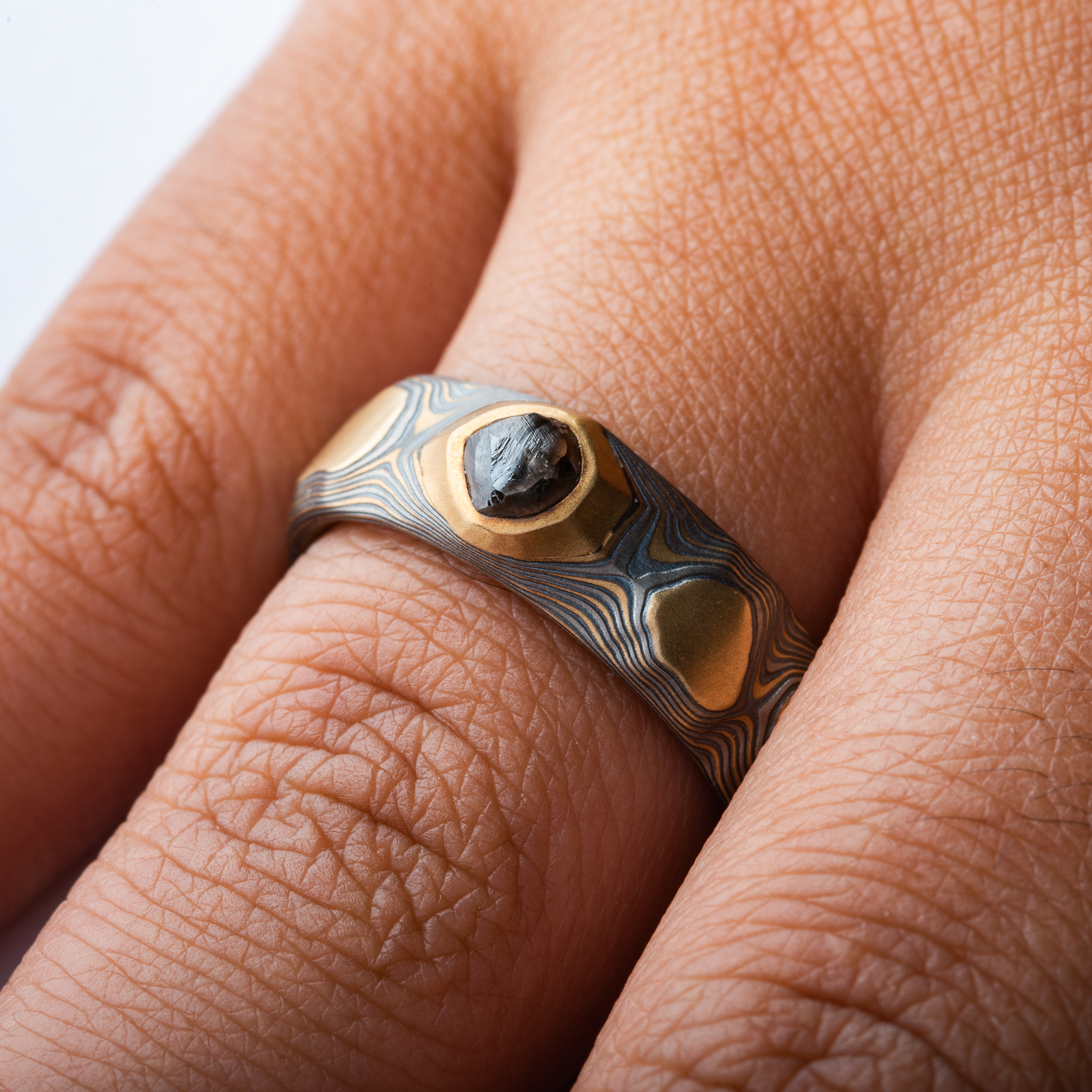 yellow gold, silver and palladium metal with striped Guri Bori, mokume gang with a raw diamond inset in the yellow gold