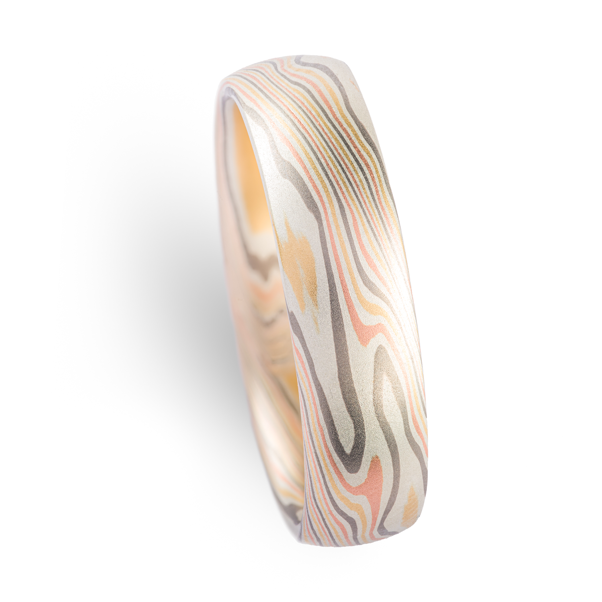 Mokume gane wedding band made in twisting pattern, made with yellow and red gold, palladium and silver.