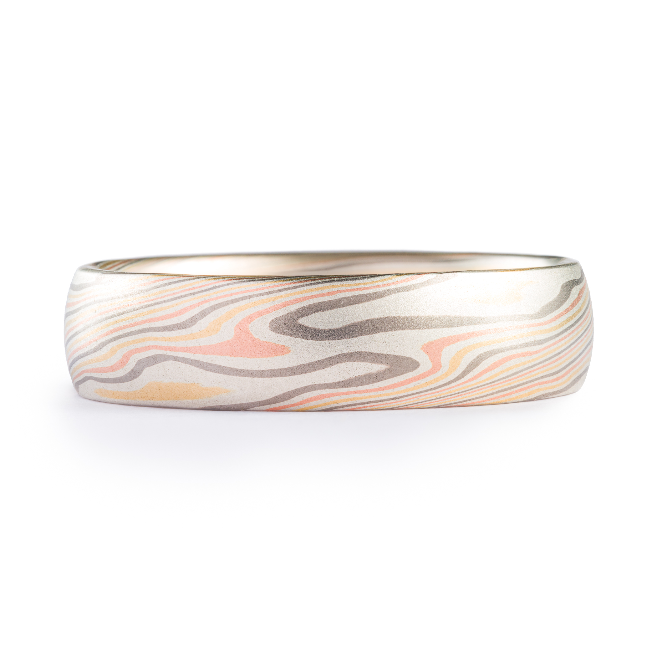 Mokume gane wedding band made in twisting pattern, made with yellow and red gold, palladium and silver.