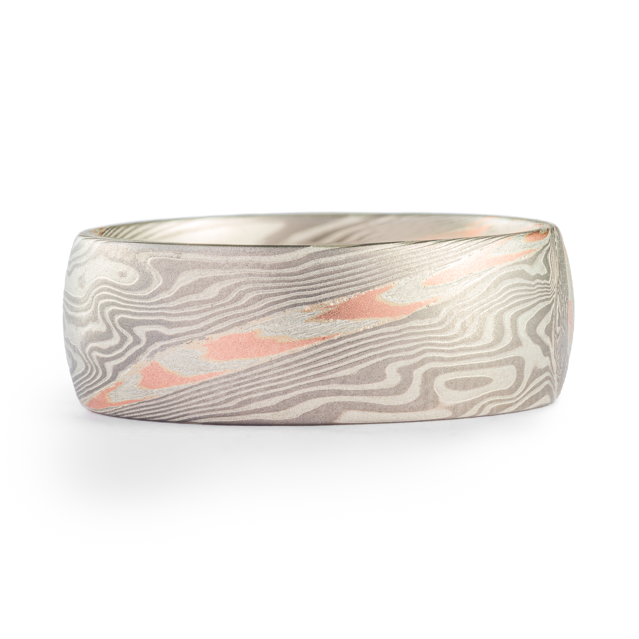 Silver and palladium mokume gane patterned ring, with a single layer of red gold and silver, also patterned.