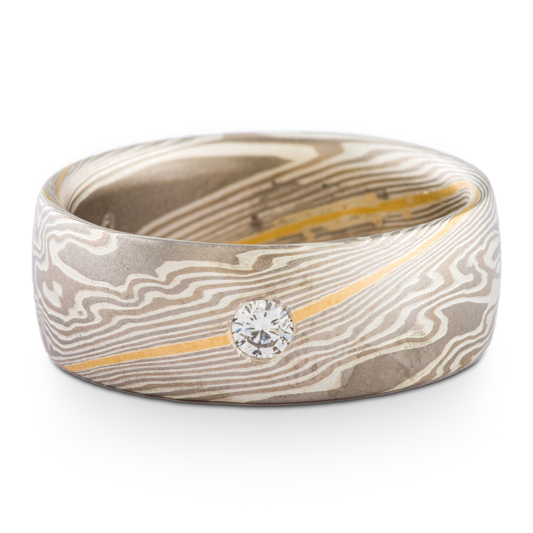Wide mokume gane men's wedding ring, with a single round diamond flush set into the band, the ring is overall made of layers of gray metals, with one stripe of gold.