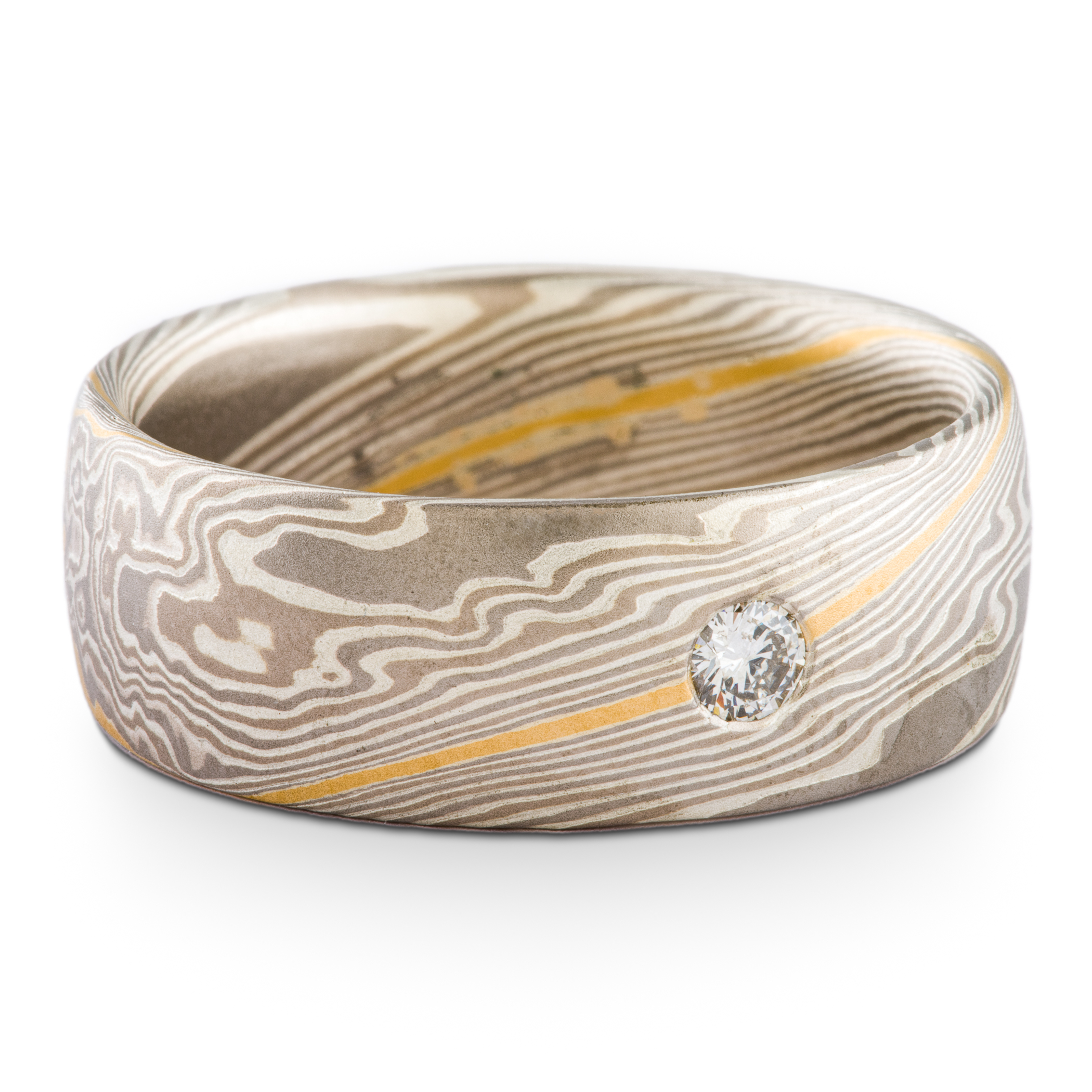 Wide mokume gane men's wedding ring, with a single round diamond flush set into the band, the ring is overall made of layers of gray metals, with one stripe of gold.