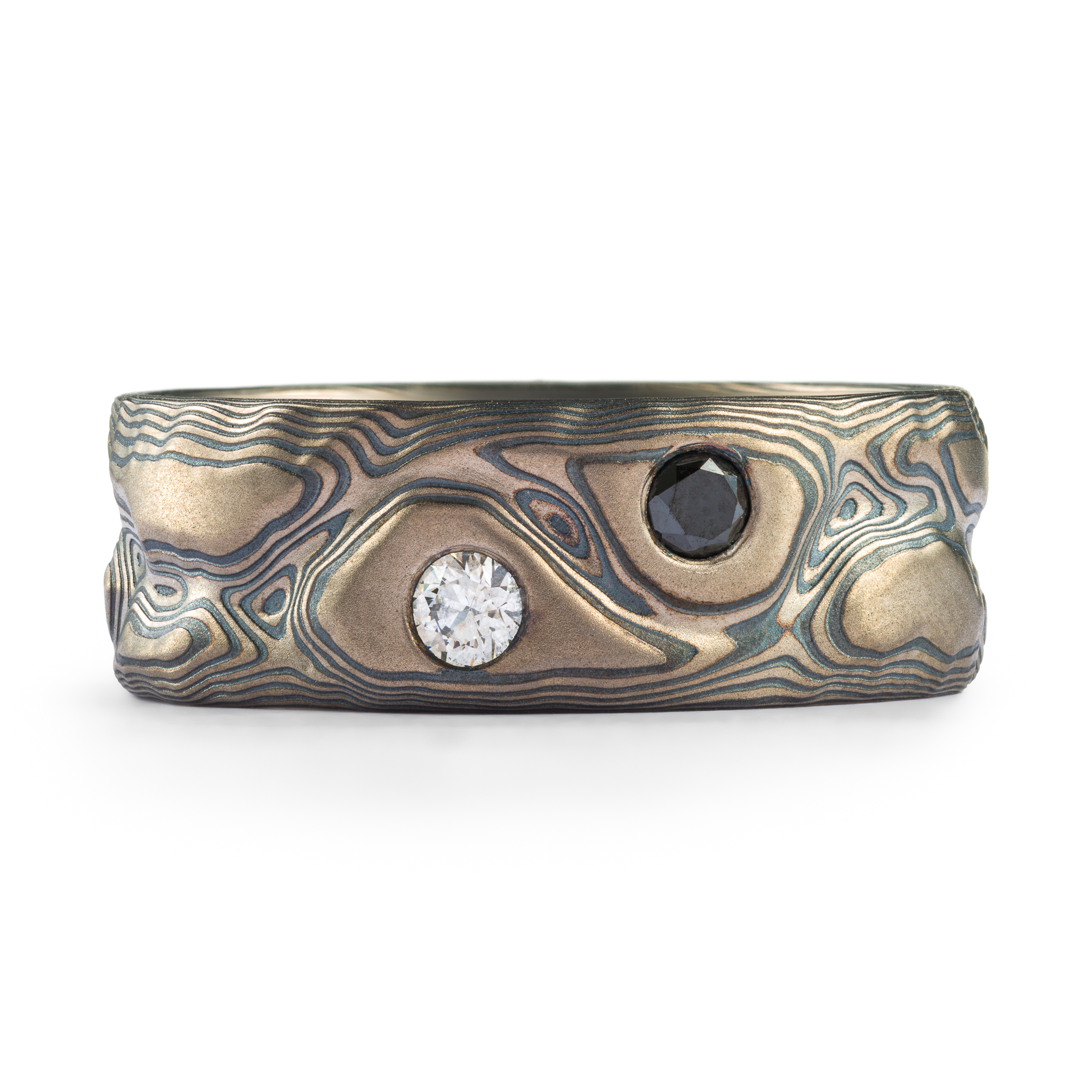 Silver and black textured mokume gane ring with two flush set round stones, one black, one white.