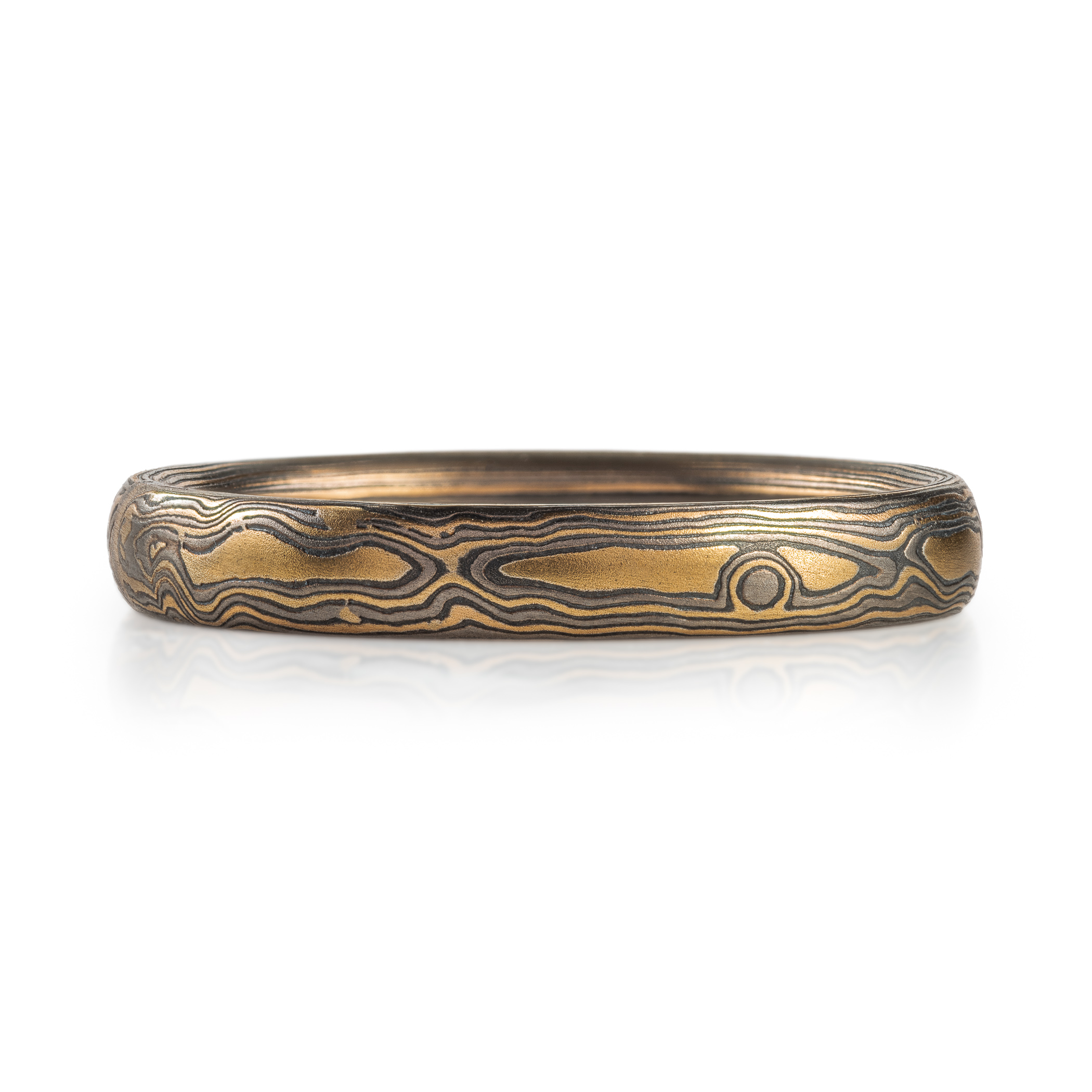 mokume gane woodgrain patterned ring made with yellow gold, palladium (dark gray) and oxidized silver (black)