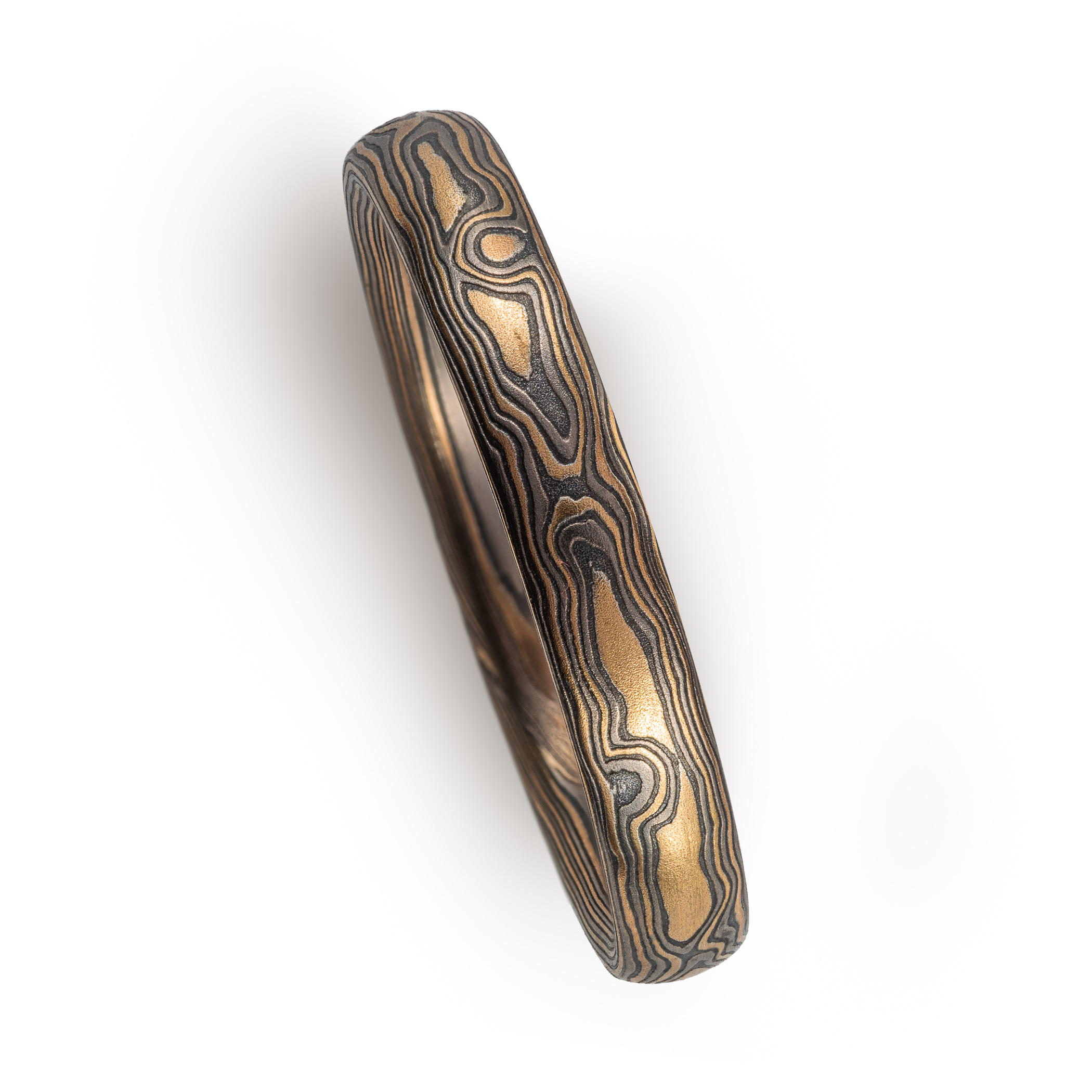 mokume gane woodgrain patterned ring made with yellow gold, palladium (dark gray) and oxidized silver (black)