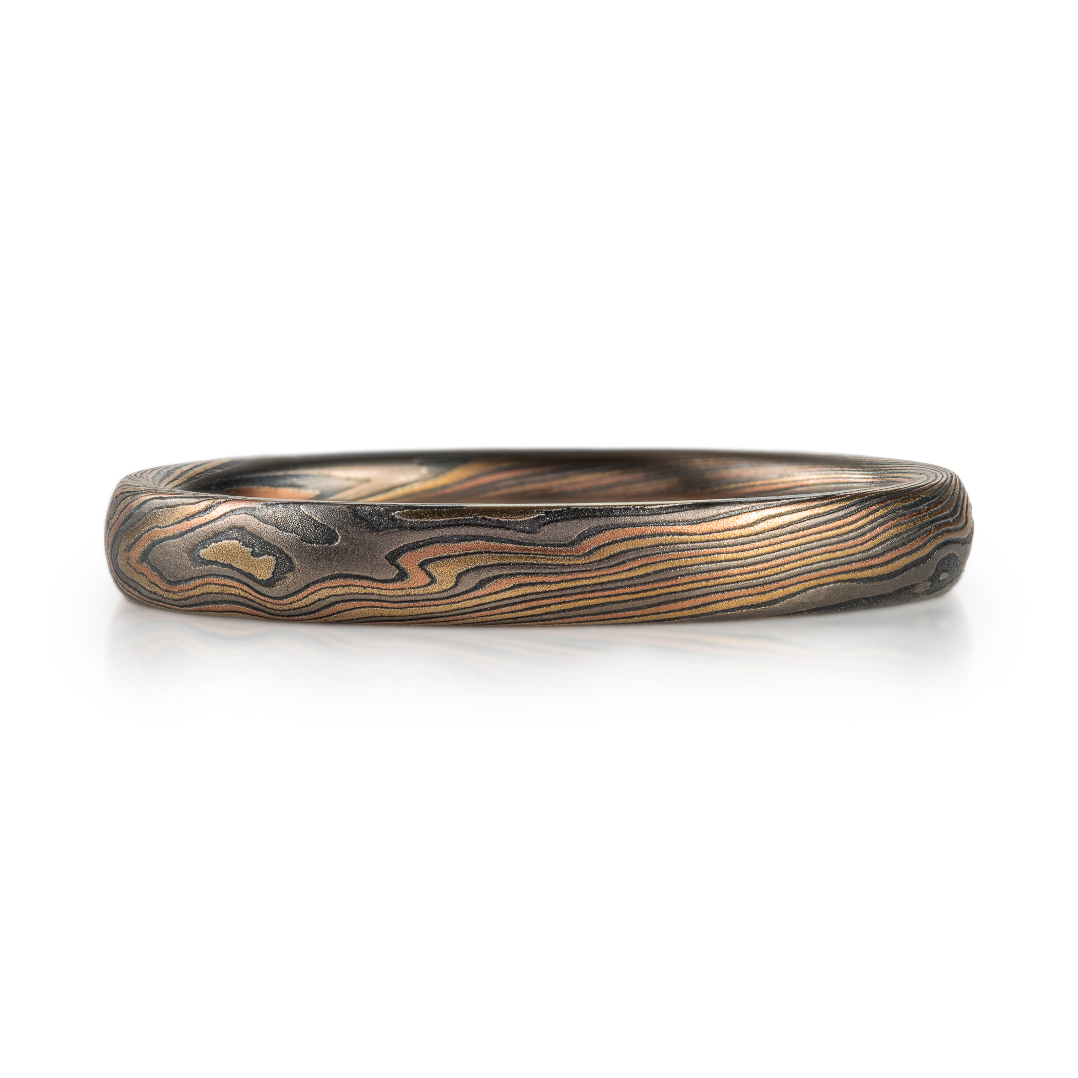 Narrow mokume gane patterned ring made with multiple metals, for an overall woodsy, nature inspired ring.