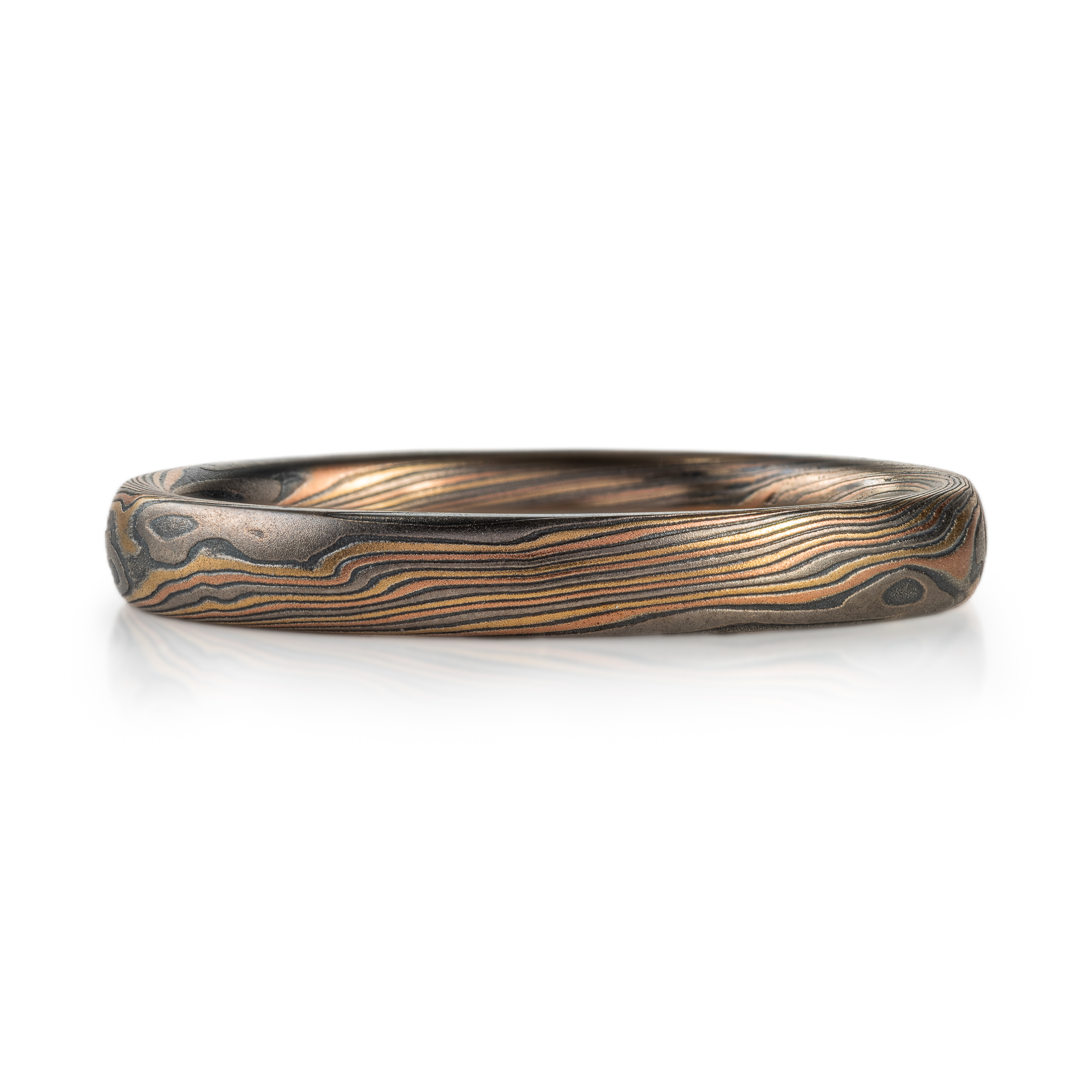Narrow mokume gane patterned ring made with multiple metals, for an overall woodsy, nature inspired ring.