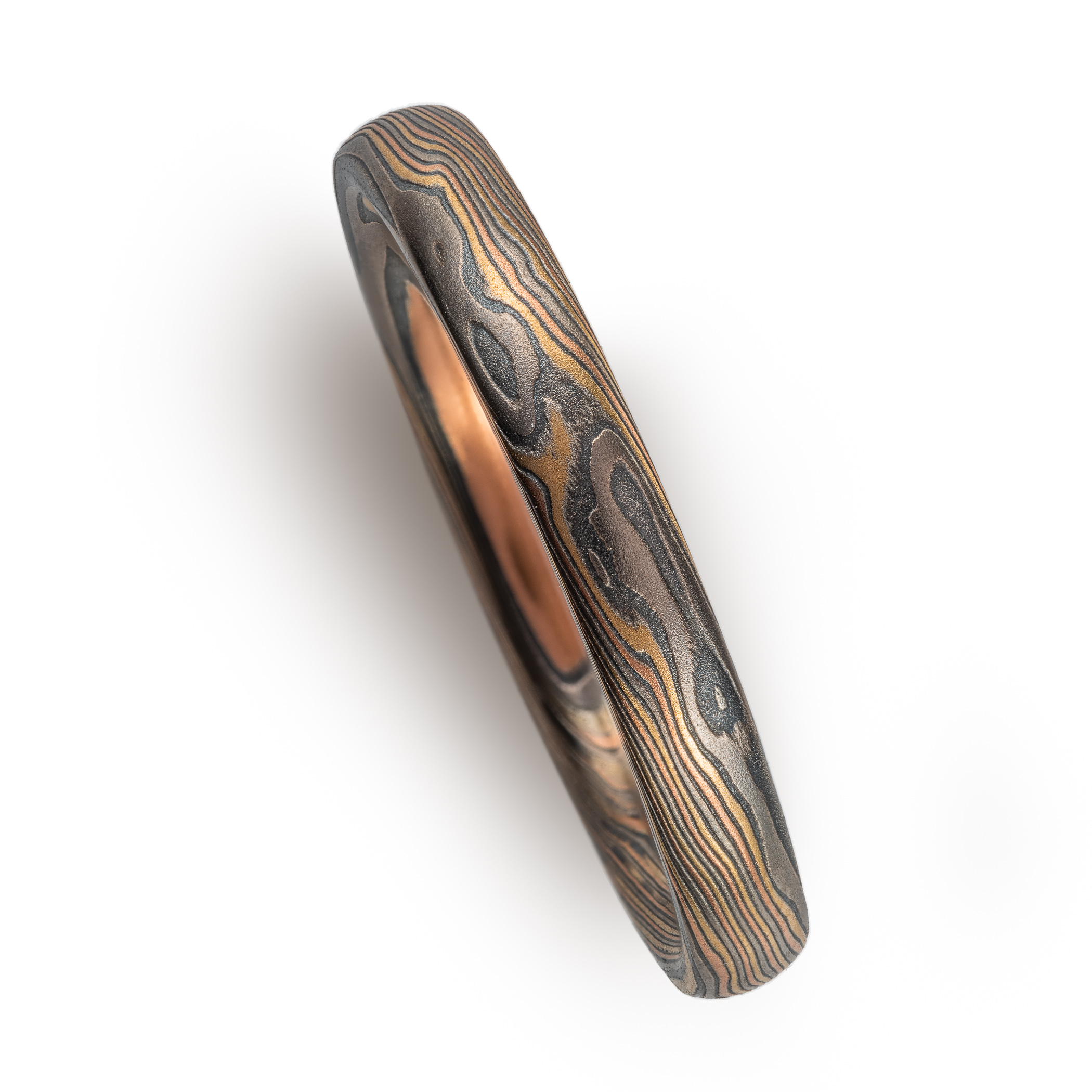 Narrow mokume gane patterned ring made with multiple metals, for an overall woodsy, nature inspired ring.