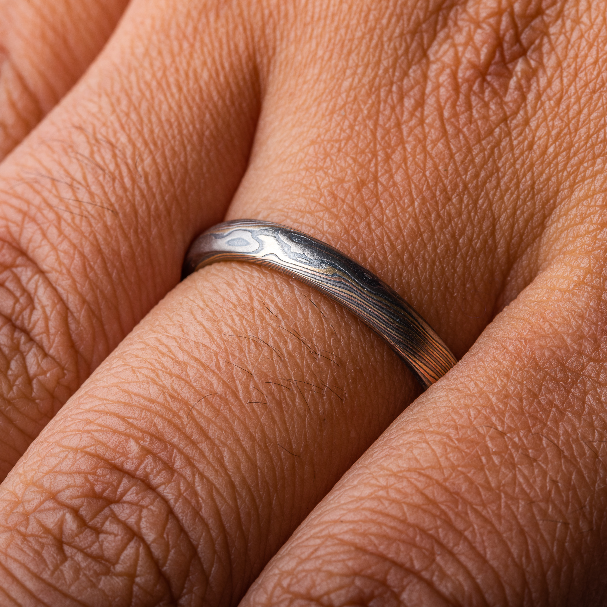 Narrow mokume gane patterned ring made with multiple metals, for an overall woodsy, nature inspired ring.