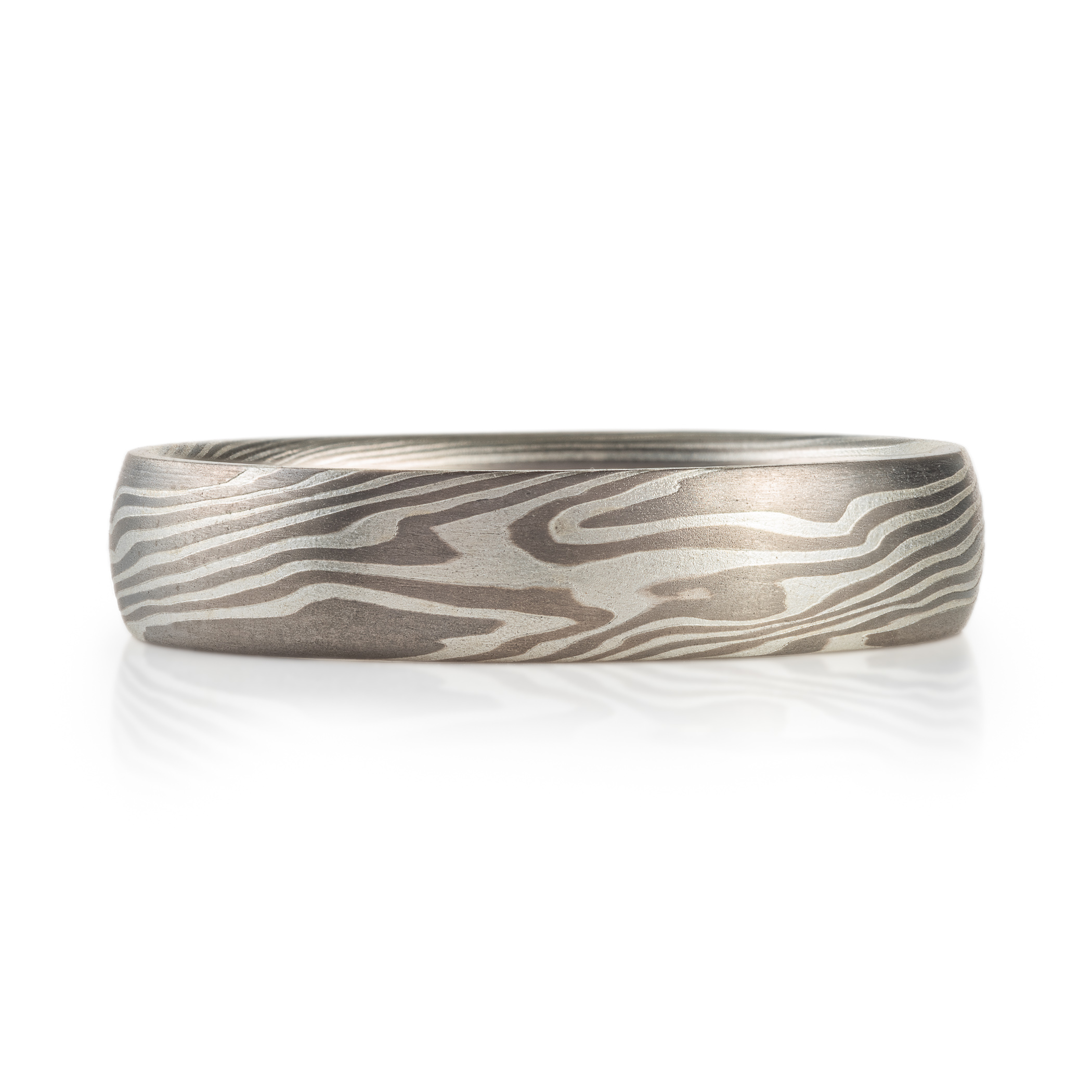 Mokume gane ring made with light and dark gray metals, twisted and patterned resembling woodgrain.