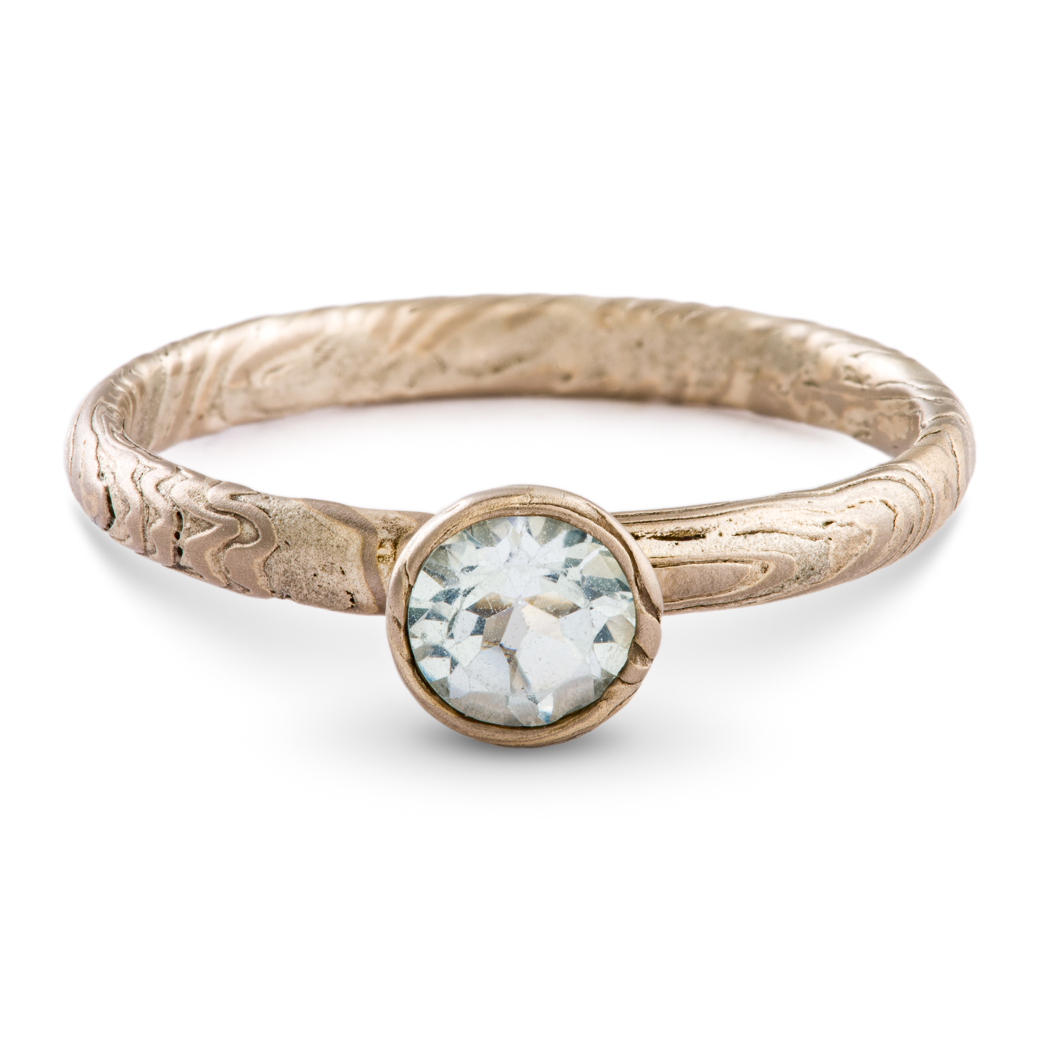 Mokume gane ring made in silvery palette, textured, with a light blue round stone.