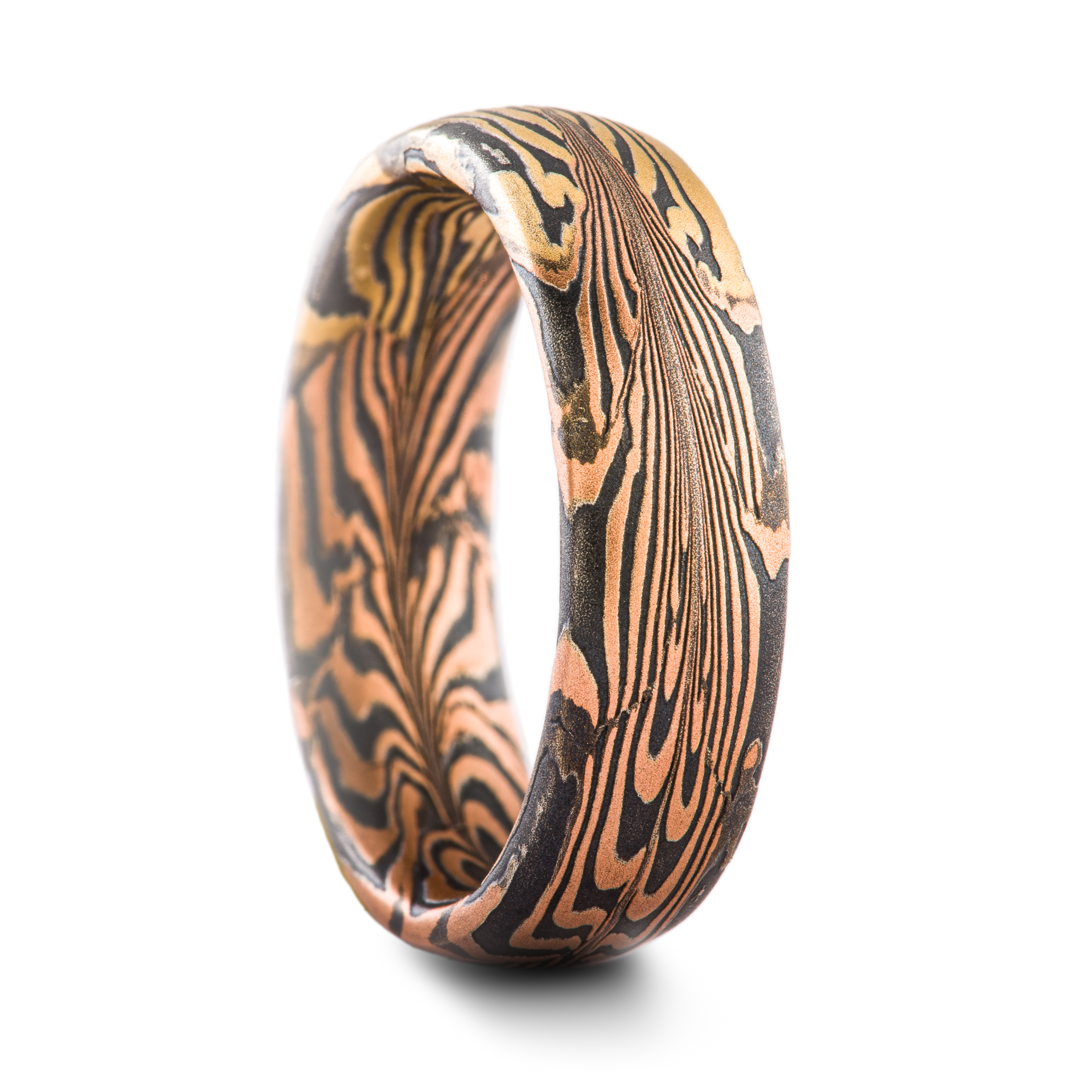 Uniquely patterned mokume gane ring in half red gold, half yellow gold, with oxidized silver.