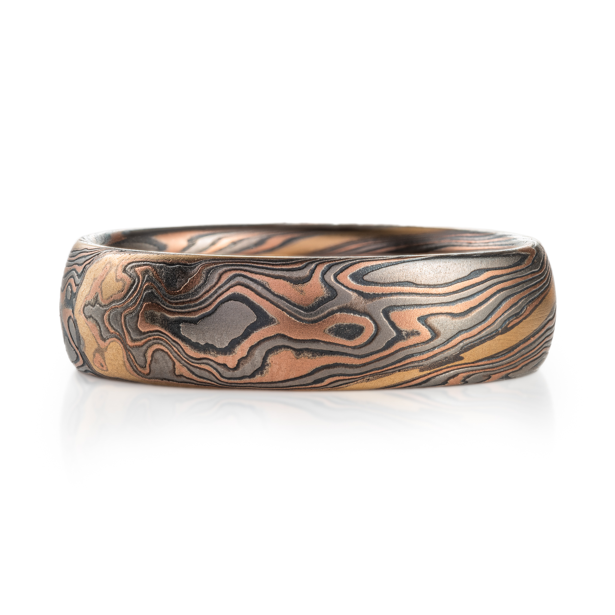 hand carved and handmade twisted metal and stripes of gold. yellow gold , red gold, silver and palladium swirled metal. wide, carved ring for a man