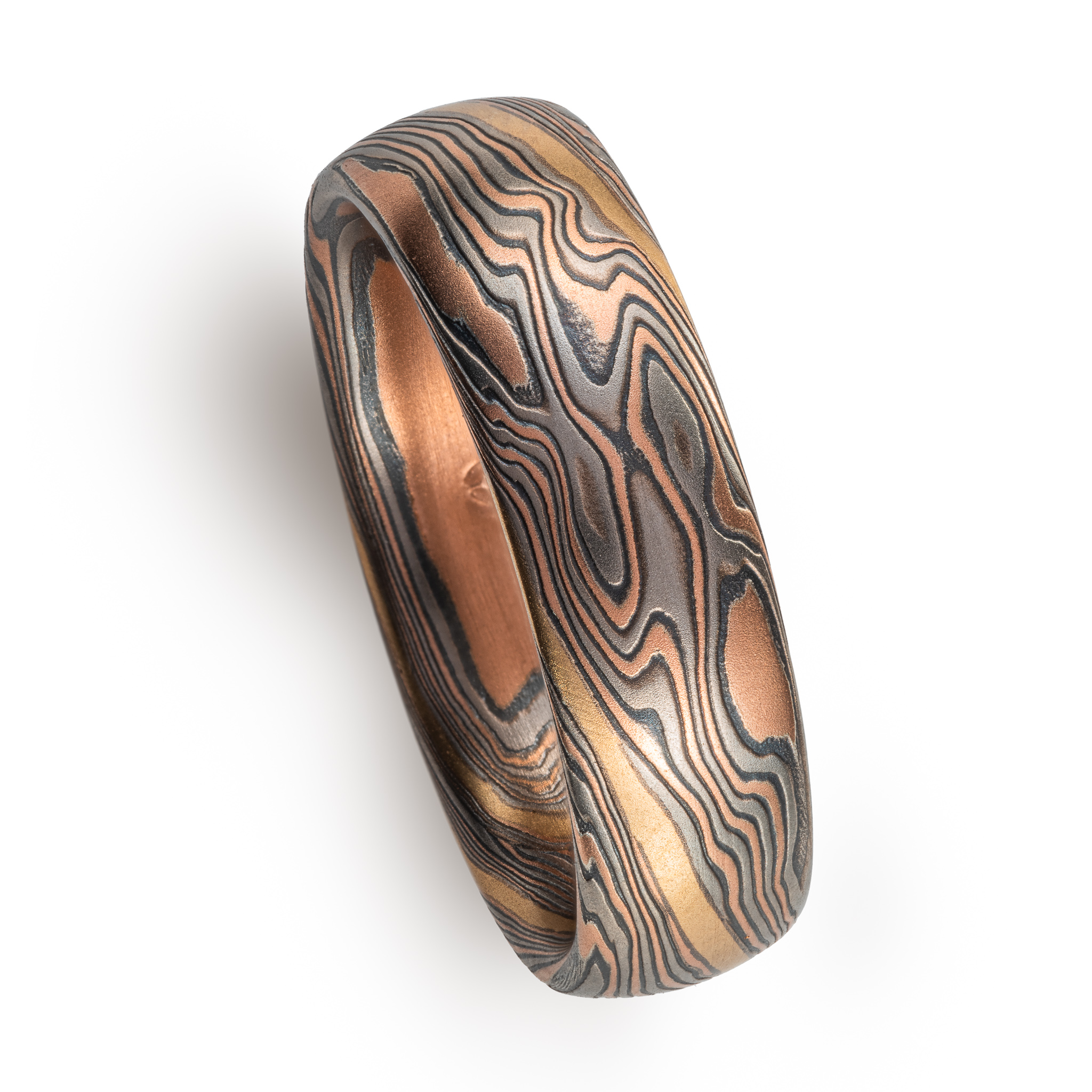 hand carved and handmade twisted metal and stripes of gold. yellow gold , red gold, silver and palladium swirled metal. wide, carved ring for a man