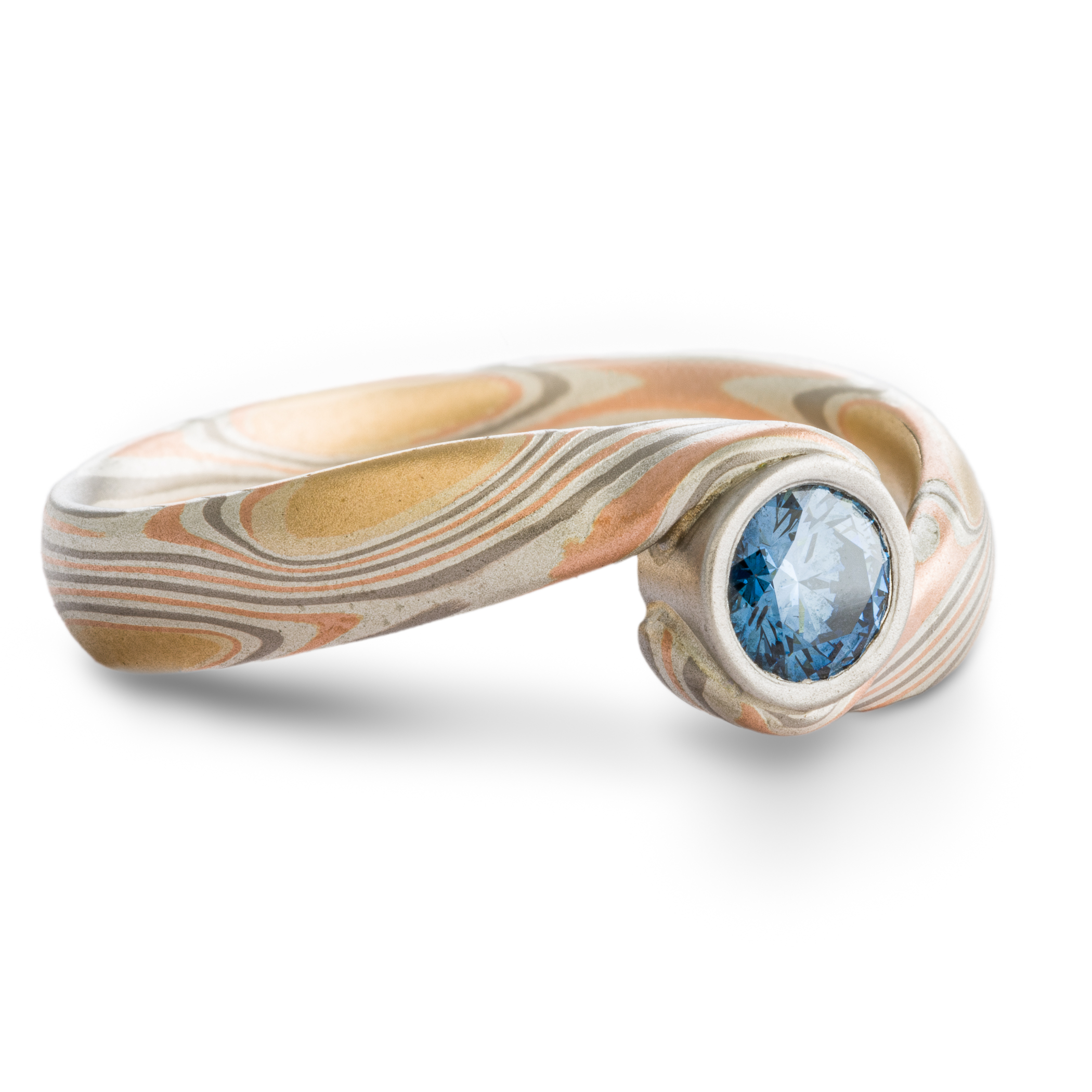 Blue Diamond mokume gane ring made with golds, palladium and silver in a swirling pattern, with a gently sloping and twisted band.