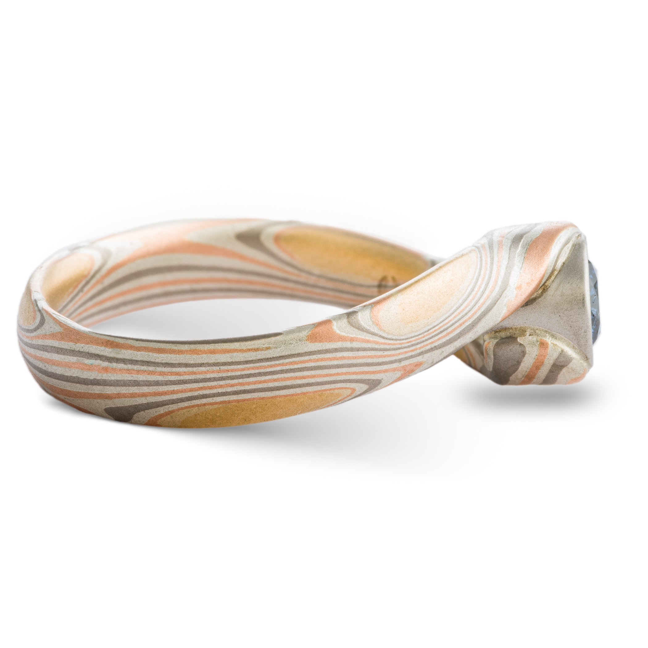 Blue Diamond mokume gane ring made with golds, palladium and silver in a swirling pattern, with a gently sloping and twisted band.
