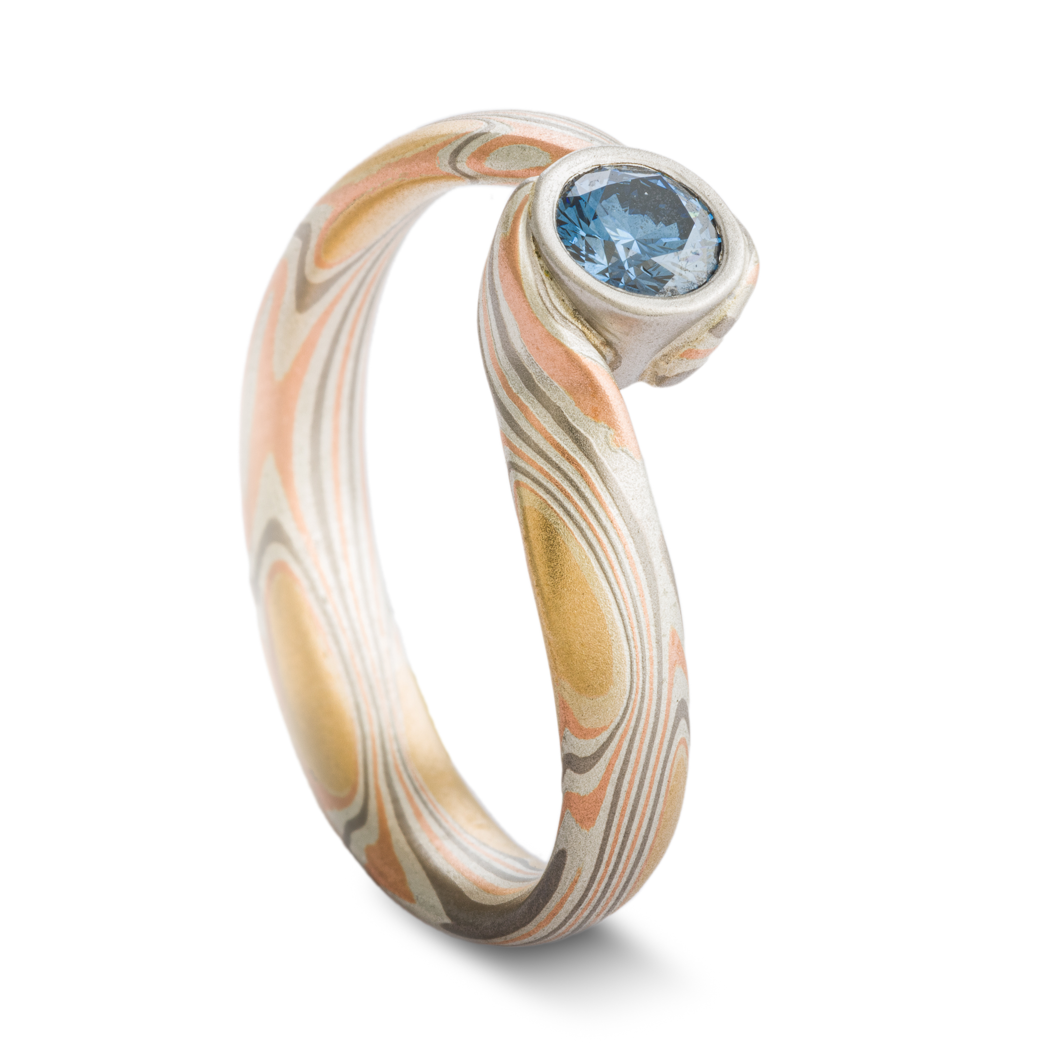 Blue Diamond mokume gane ring made with golds, palladium and silver in a swirling pattern, with a gently sloping and twisted band.