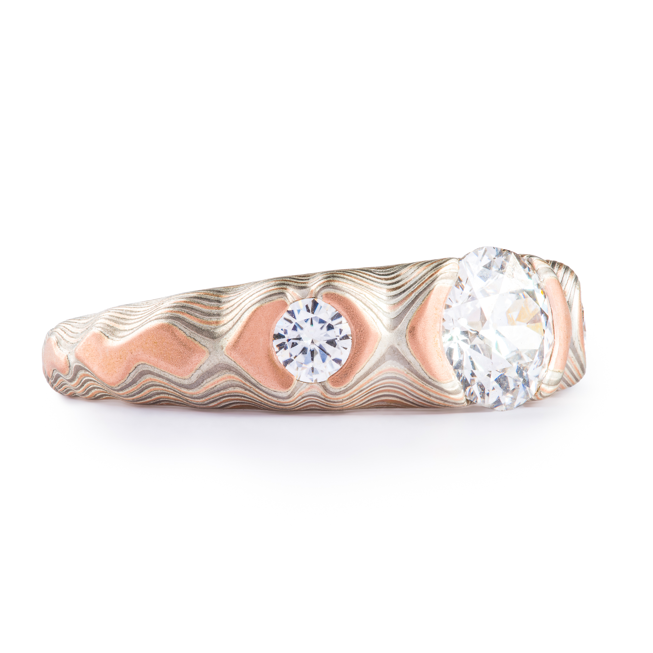 Diamond mokume gane cathedral style ring with one large center stone and two smaller side stones, made with red gold, palladium and silver.
