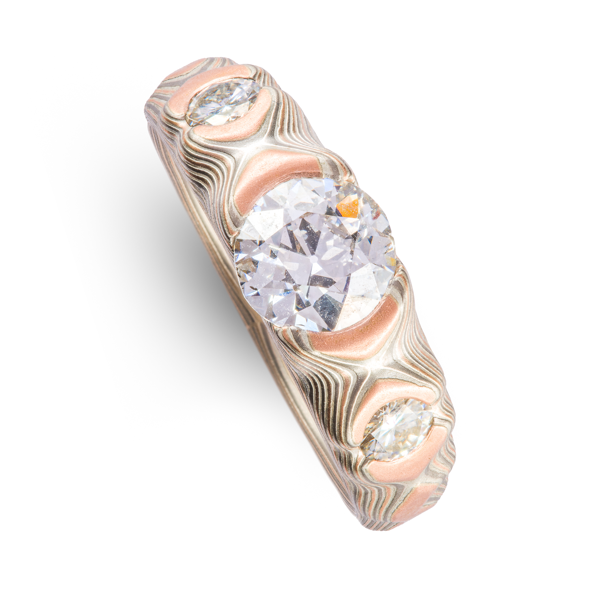 Diamond mokume gane cathedral style ring with one large center stone and two smaller side stones, made with red gold, palladium and silver.