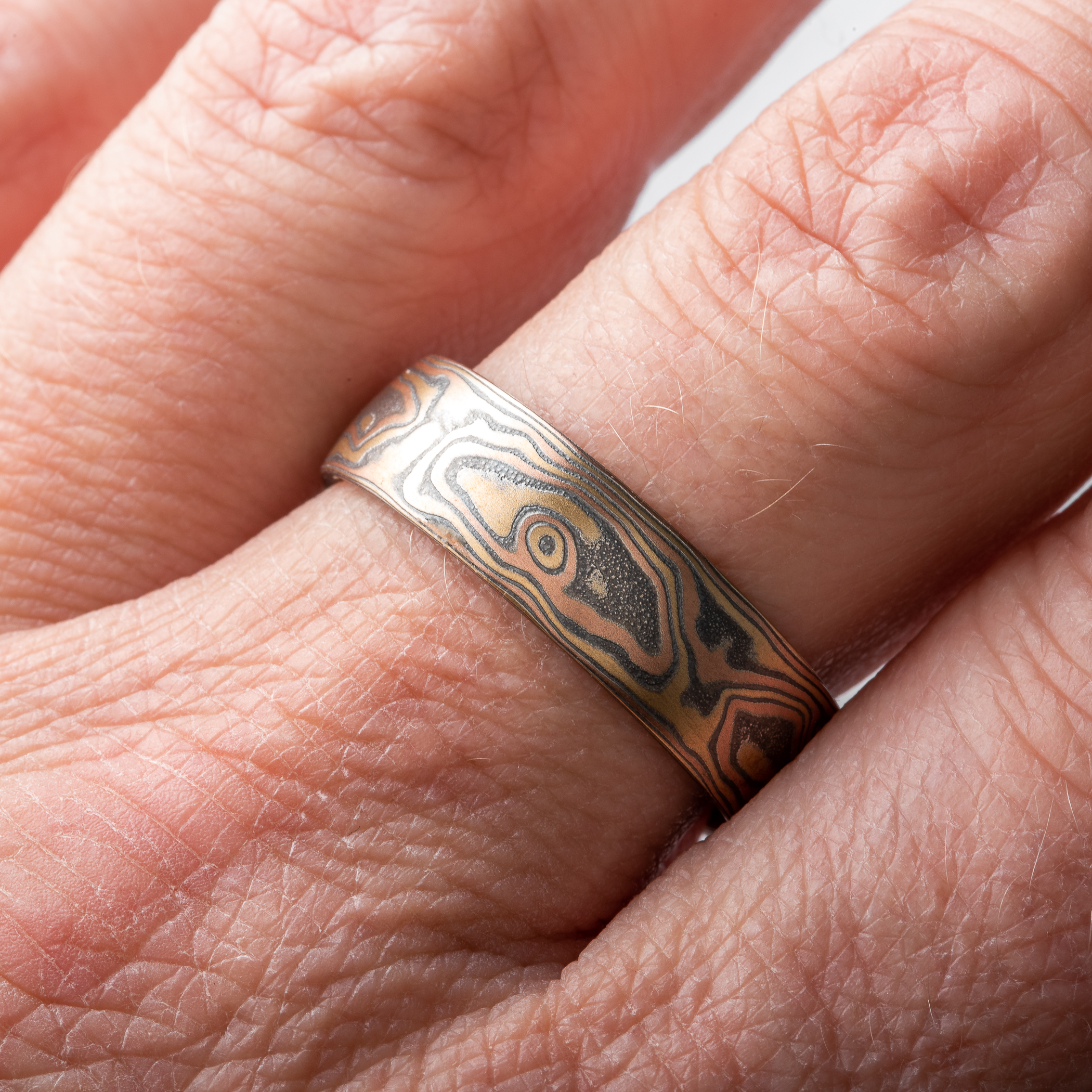 Ring made in mokume gane pattern, with red gold, yellow gold and oxidized silver.