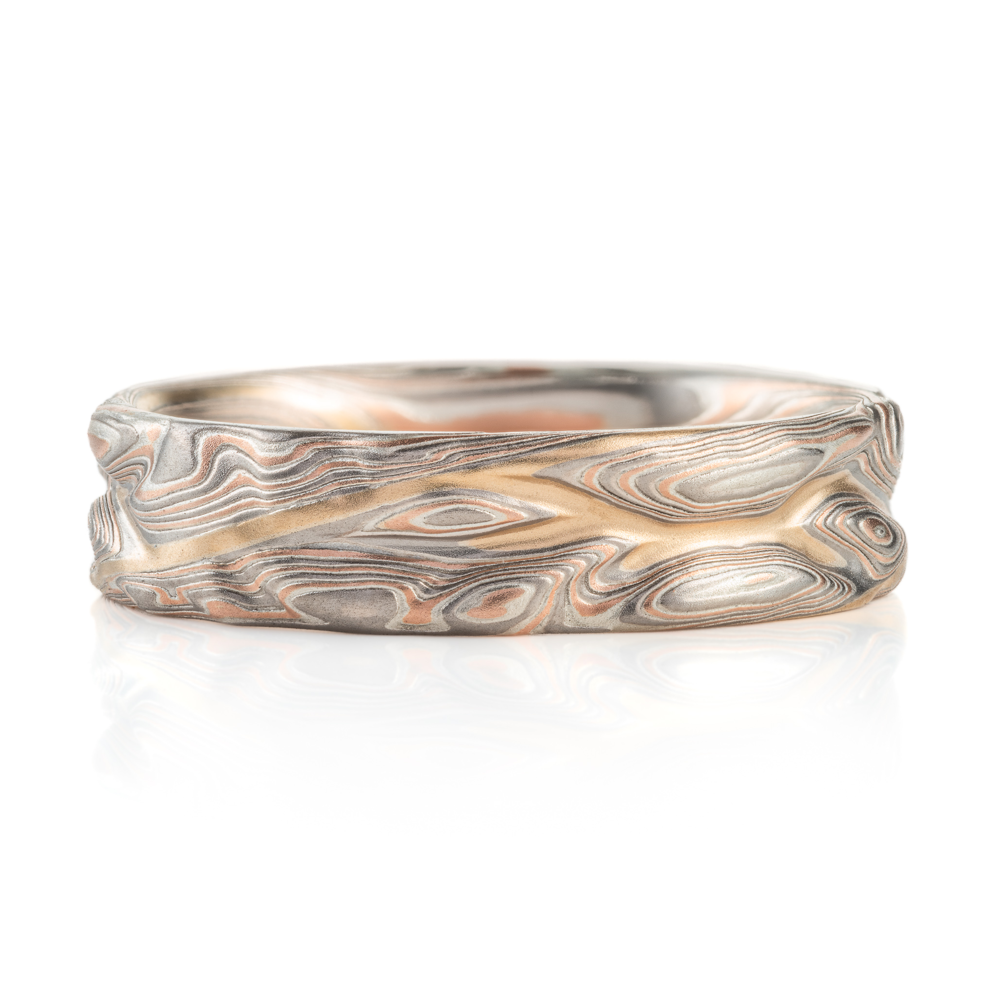 hand carved and handmade twisted metal and stripes of gold. iyellow gold , red gold, silver and palladium swirled metal. wide, carved ring for a man