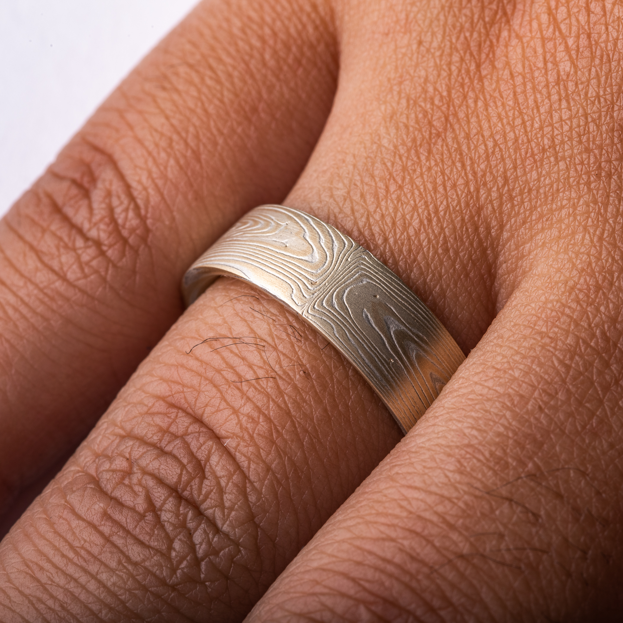 Arn Krebs mokume gane ring patterned in a subtle linear style in his vortex pattern. Made with yellow gold and silver.