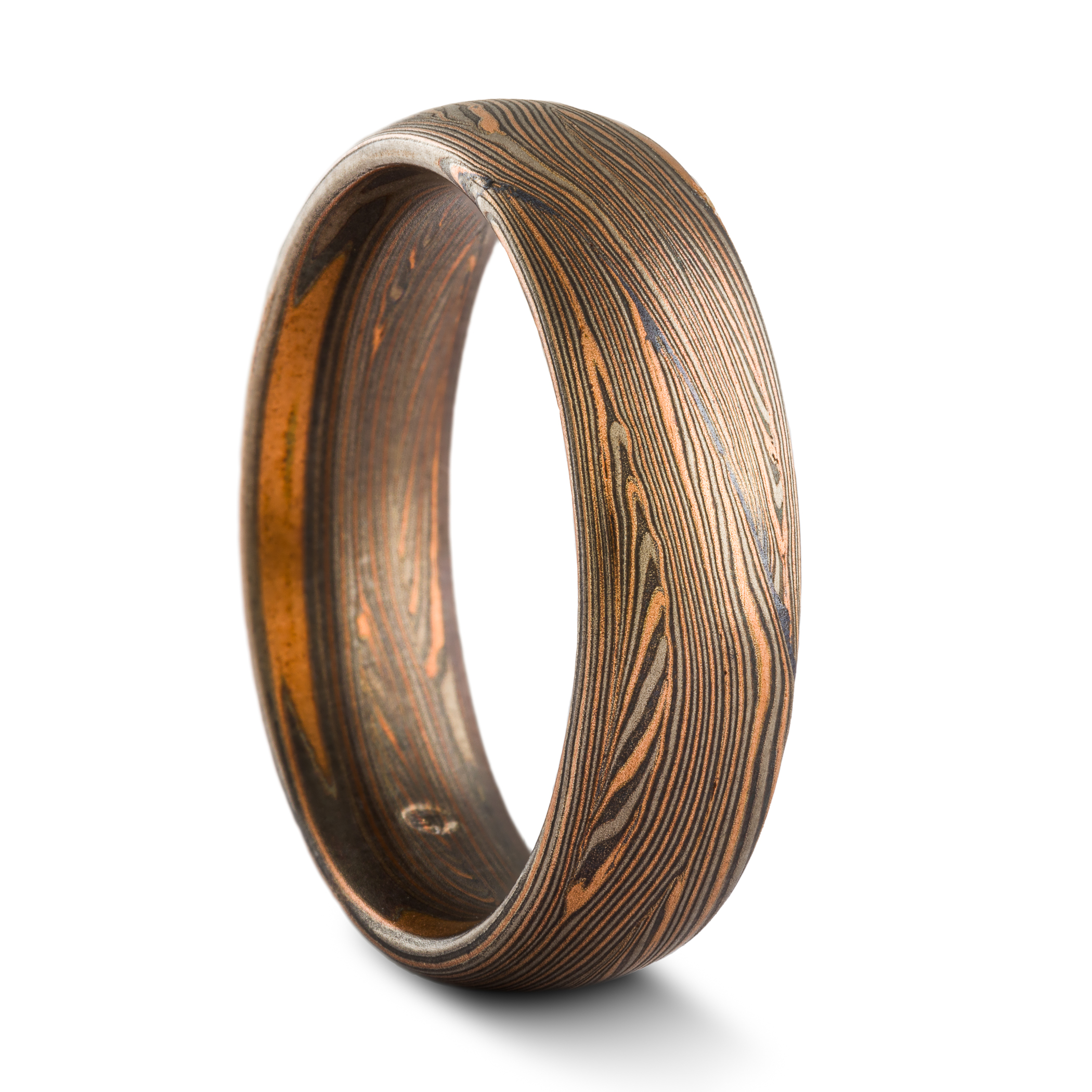 Warm toned mokume gane ring, patterned in a linear style with many layers of fine lines in alternating red gold, palladium and oxidized silver. Medium width band with a domed profile.