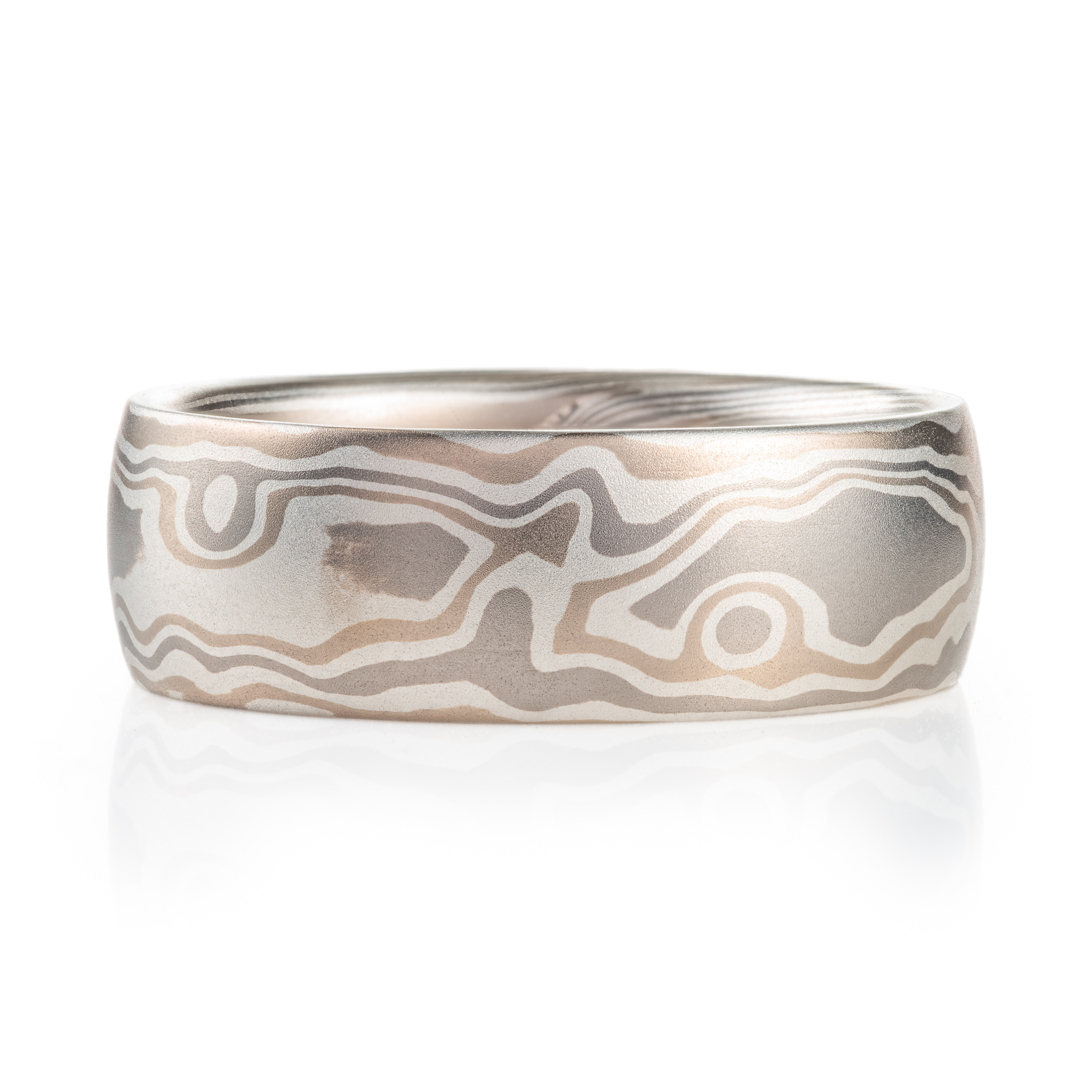 mokume gane ring made with light silvery metals in a pattern resembling woodgrain.