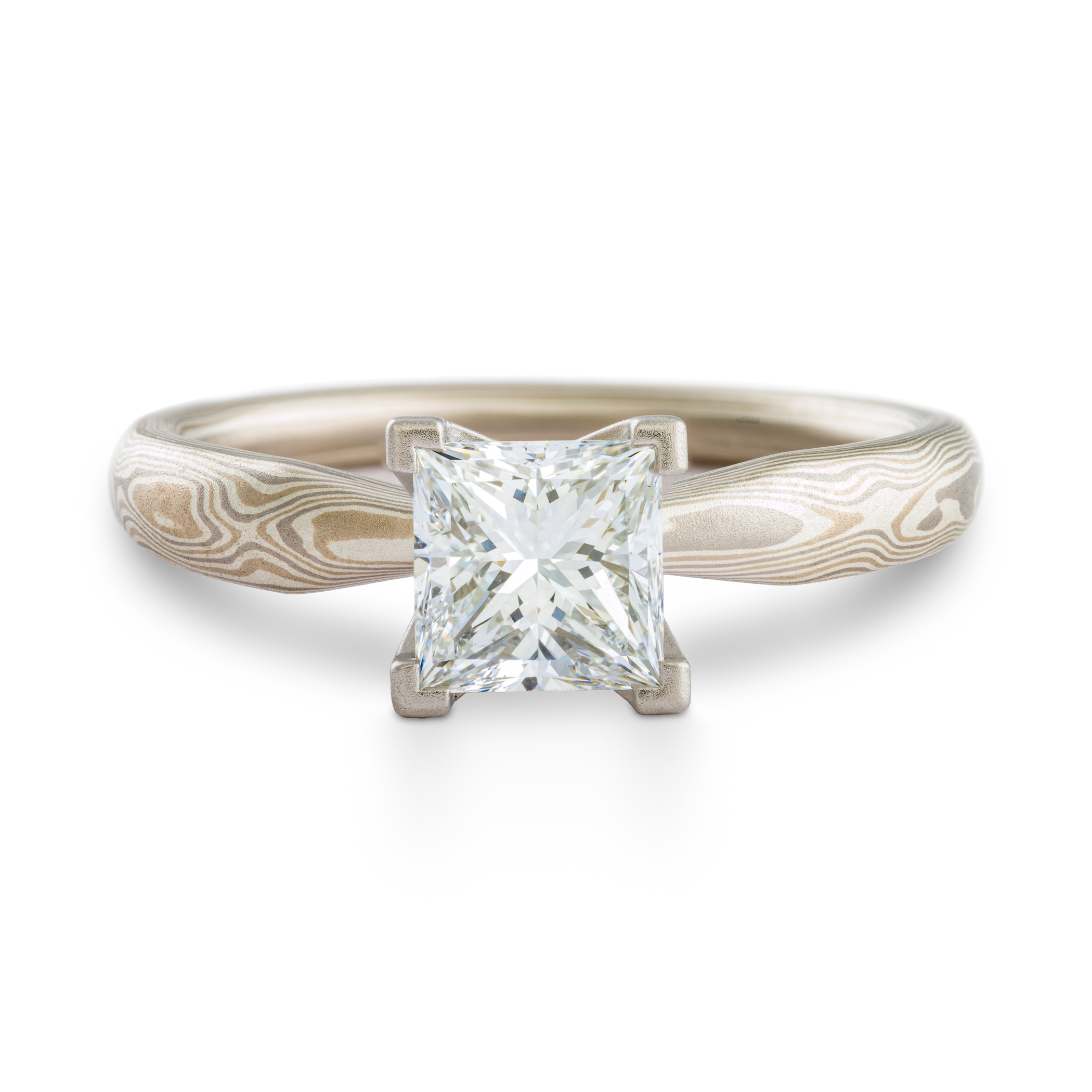 solitaire style mokume gane engagement ring with square diamond set in prongs, ring has an overall silvery palette and a woodgrain style