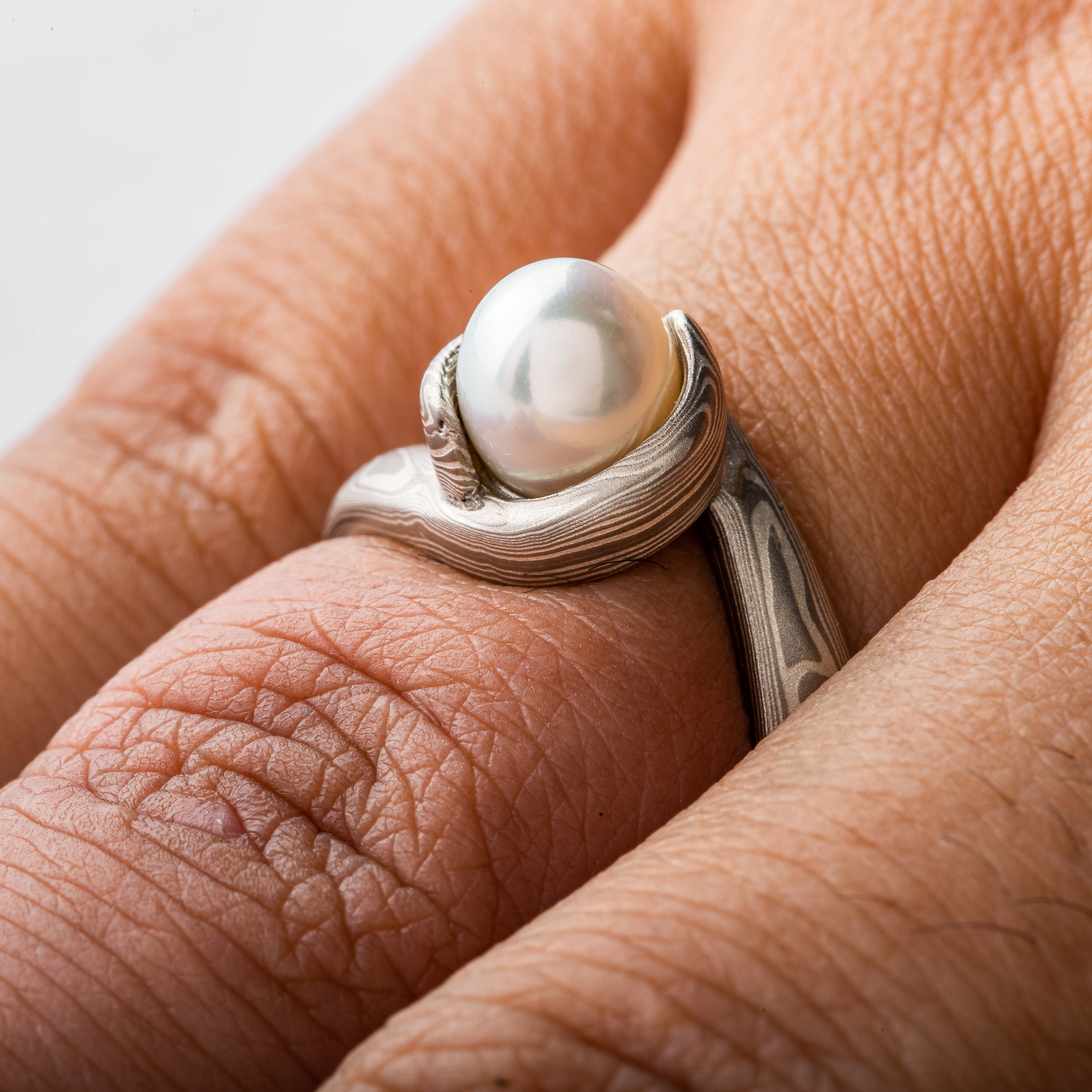 Mokume Gane ring wedding ring or engagement ring bypass style setting by arn krebs, woodgrain pattern and ash palette, white pearl, low dome, sterling silver and palladium