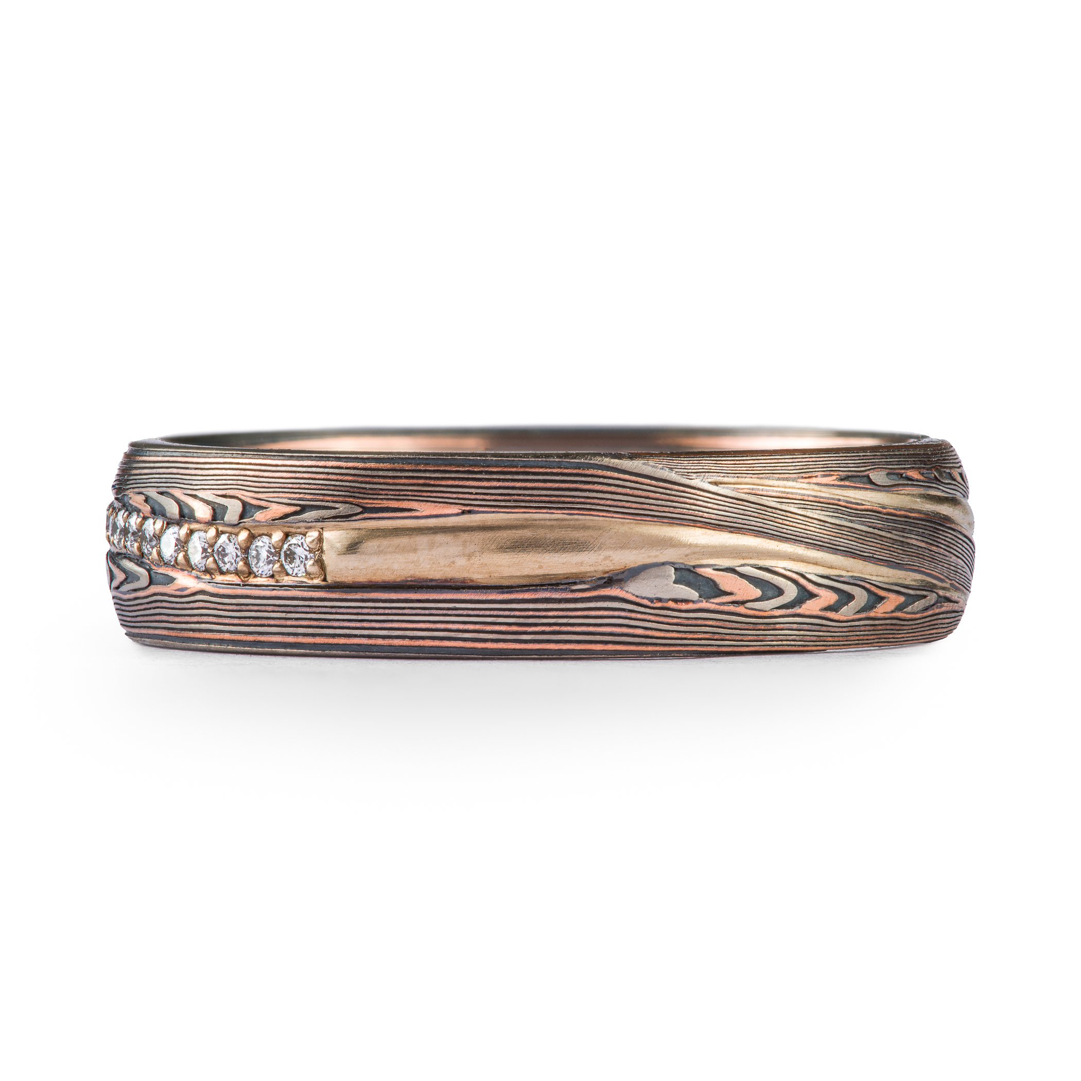 mokume gane patterned ring, red gold palladium and oxidized silver, with a line of diamonds set in the center of the band. The line gently curves around the patterning.