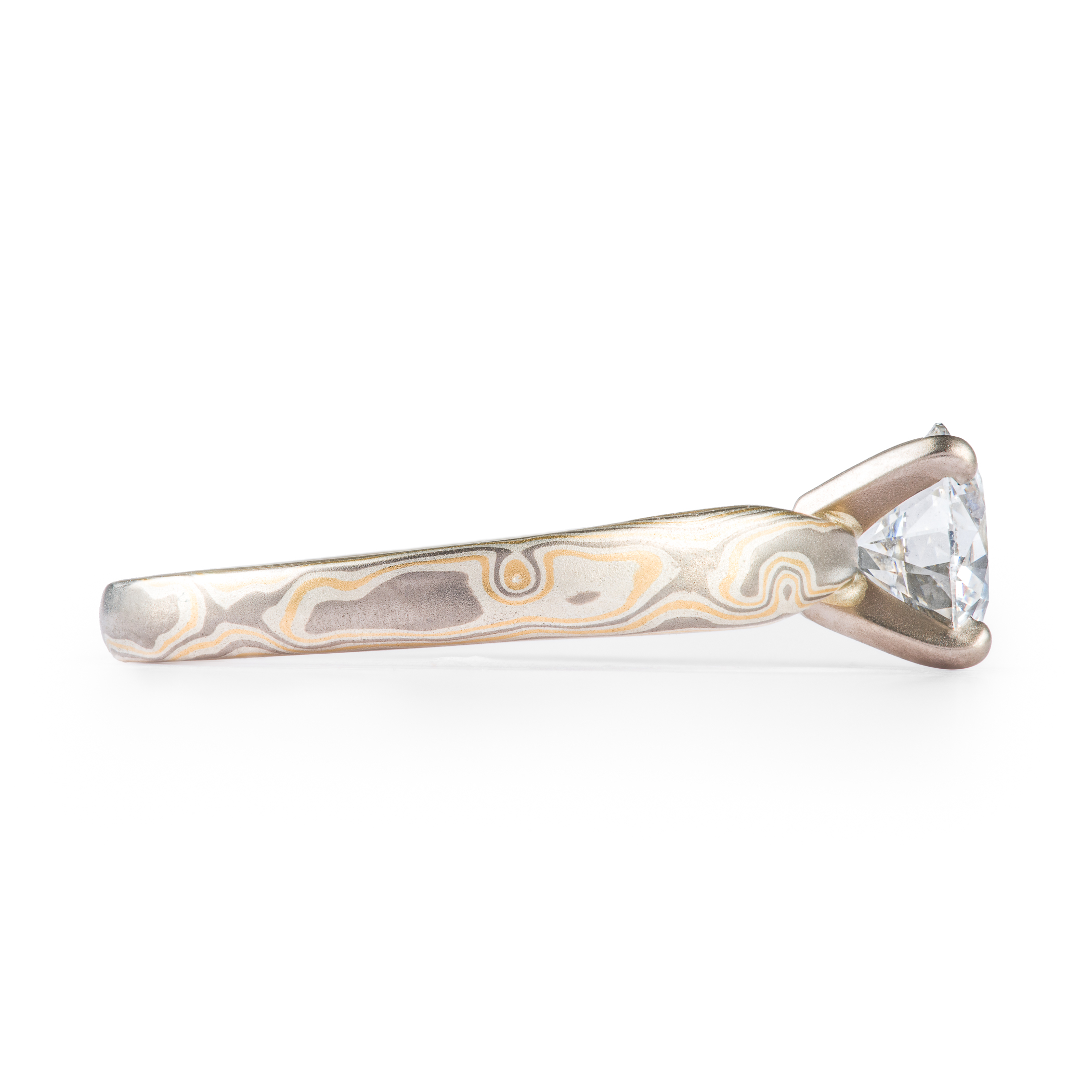 Arn Krebs mokume engagement ring, patterned in a woodgrain style with yellow gold and silver and gray metals, with a solitaire round diamond set in prongs.