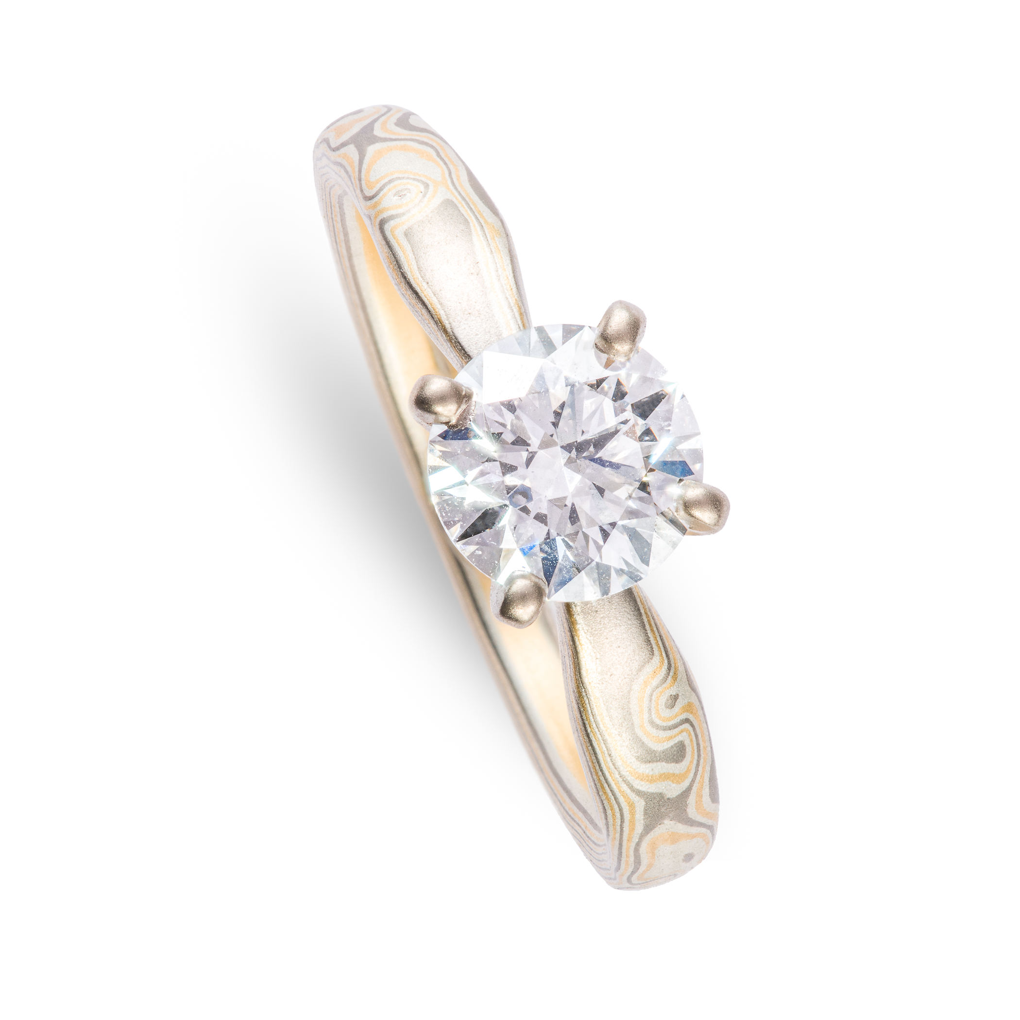 Arn Krebs mokume engagement ring, patterned in a woodgrain style with yellow gold and silver and gray metals, with a solitaire round diamond set in prongs.